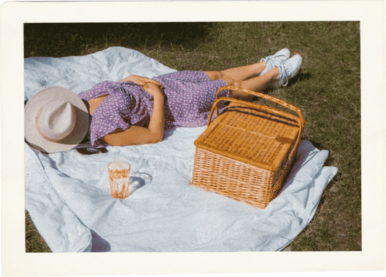 Woman relaxing on a picnic blanket in the grass.