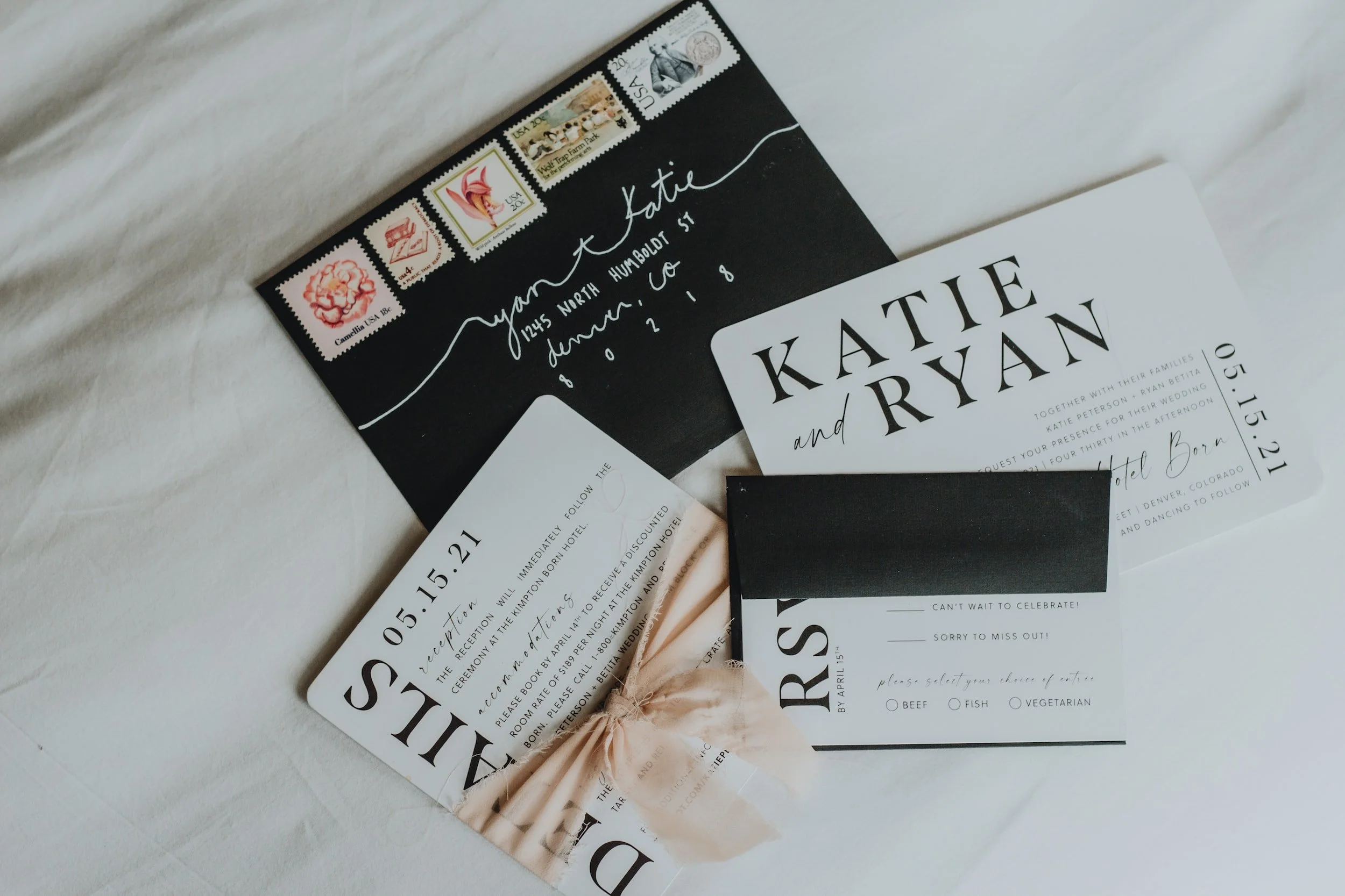 Wedding invitation cards with black and white designs, postage stamps, and an envelope.