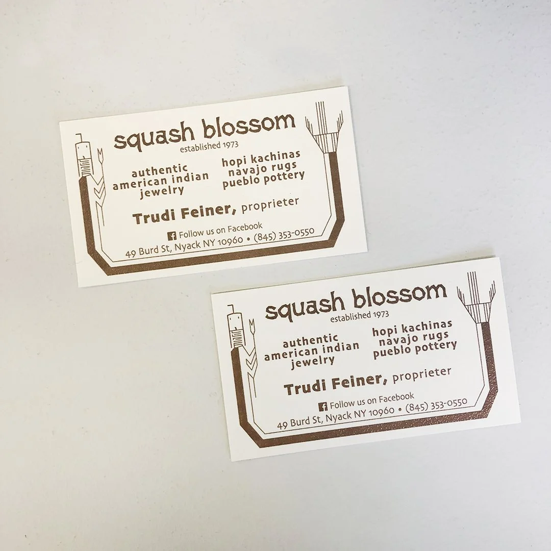 Two business cards for Squash Blossom, a jewelry and pottery shop. The cards are white with brown text and design, including a stylized plant-like logo with a square shape and lines. The address is 49 Burd St, Nyack NY 10960, and the phone number is 