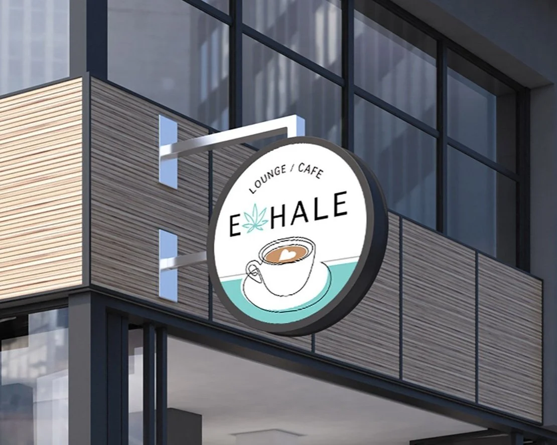 Exterior sign for E. Hale Lounge Café featuring a coffee cup with a heart and a marijuana leaf, attached to a modern building with glass windows.