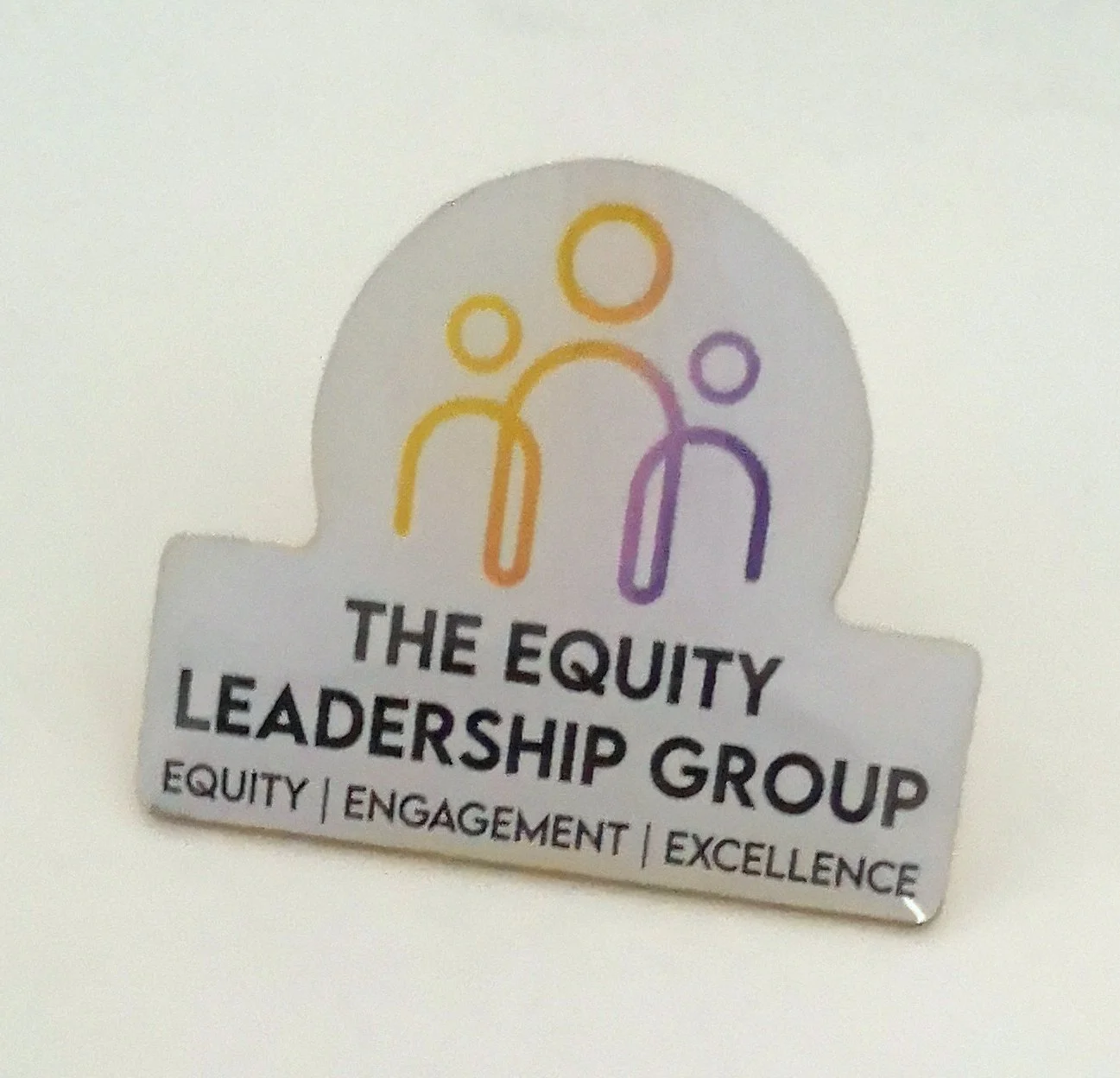 Badge with colorful outline of three people and text that reads "The Equity Leadership Group" and "Equity, Engagement, Excellence."