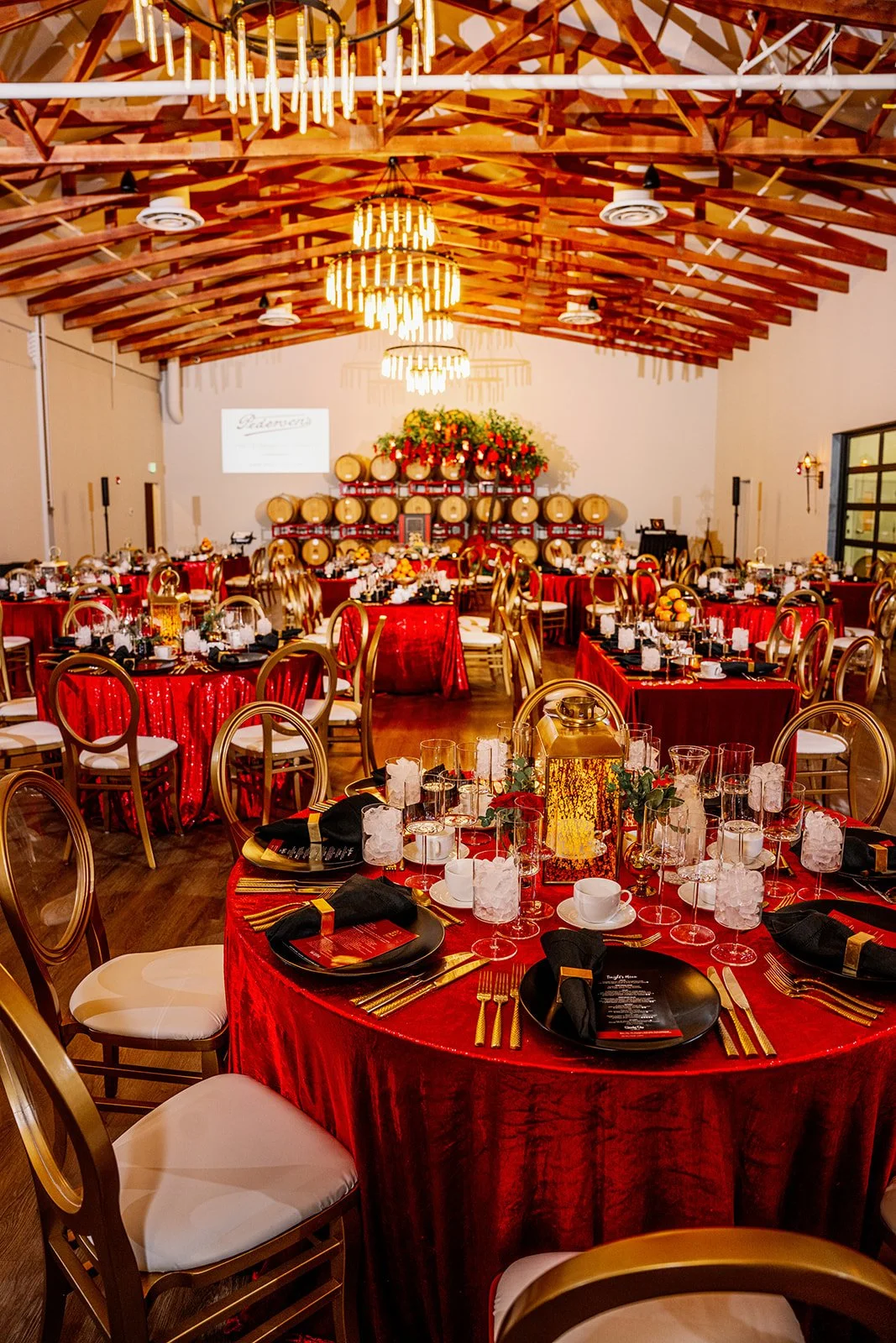 Elegant outdoor table setting with white tablecloth, decorative greenery, candles, and an assortment of small appetizers or canapés.