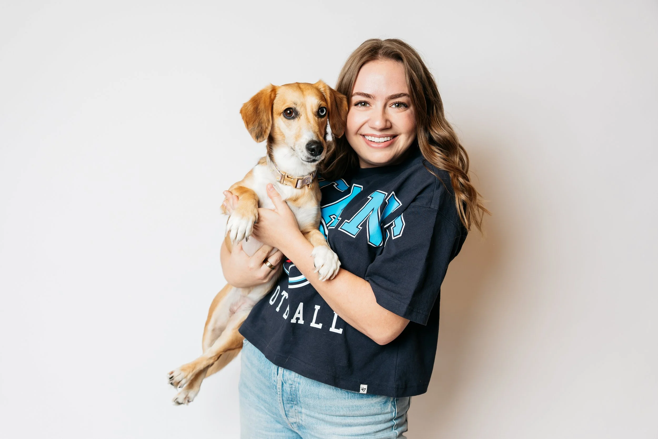 A woman holding a Dachshund mix