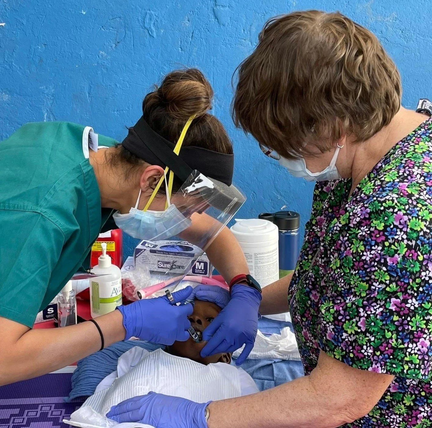 Dentist Dr. Sheena Kansal and dental hygienist Marquita Kudma perform a dental extraction on a pediatric patient.