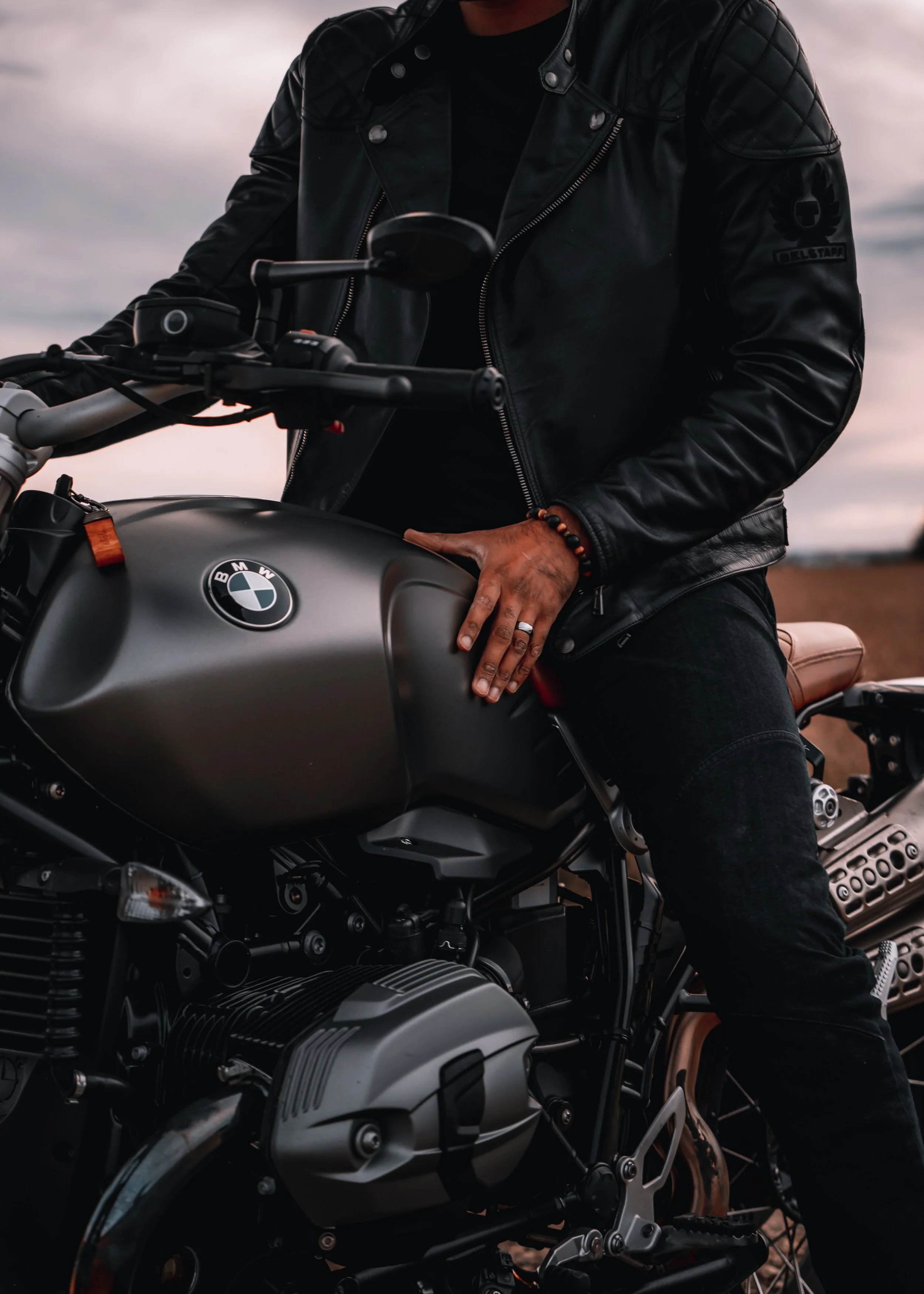 A man sitting on motorcycle holds the gas tank and handlebar | Edmonton motorcycle photographer DarkShark Media