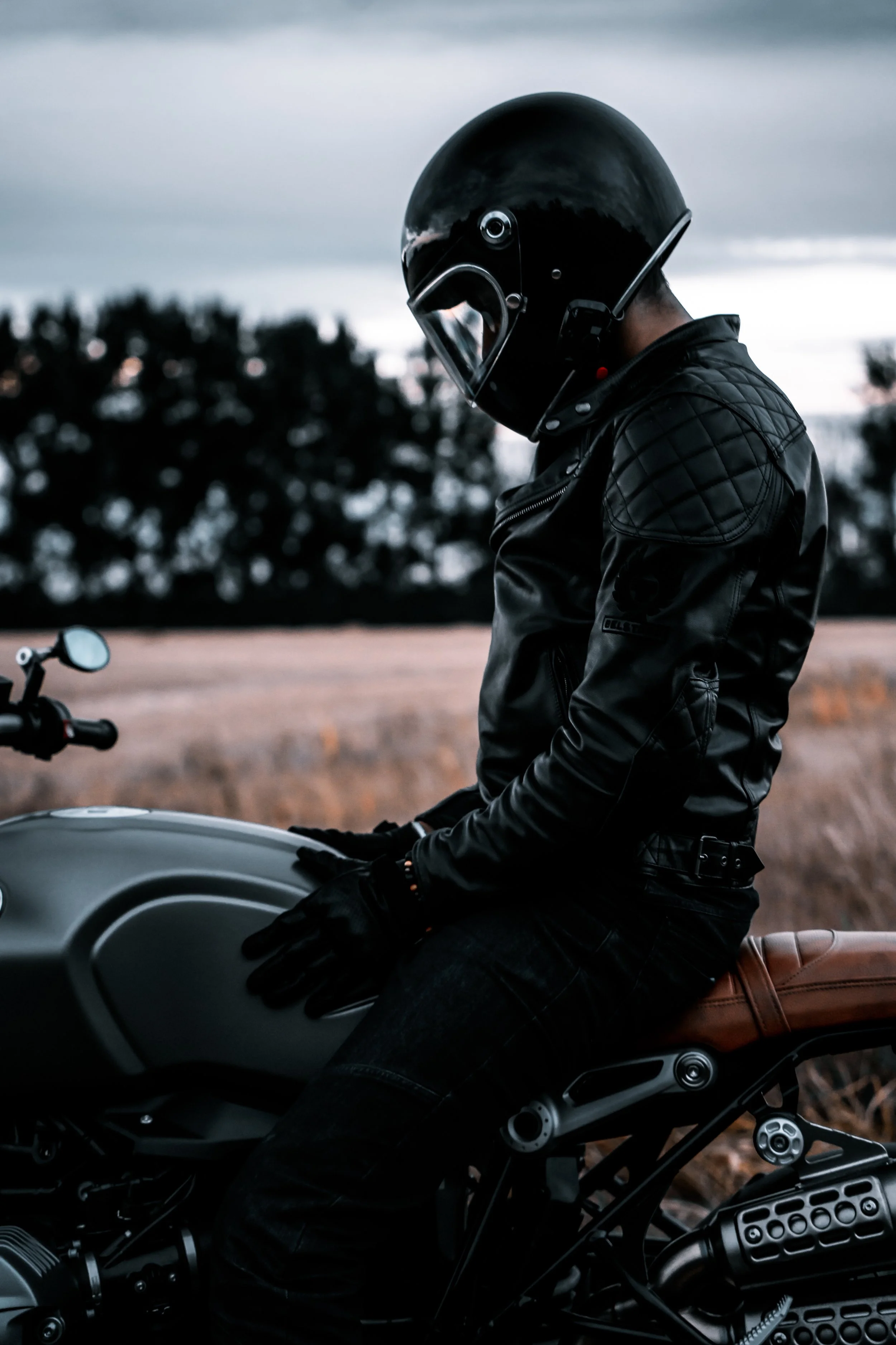 Motorcycle rider in helmet sits on bike looking down at gauges | Edmonton motorcycle photographer DarkShark Media
