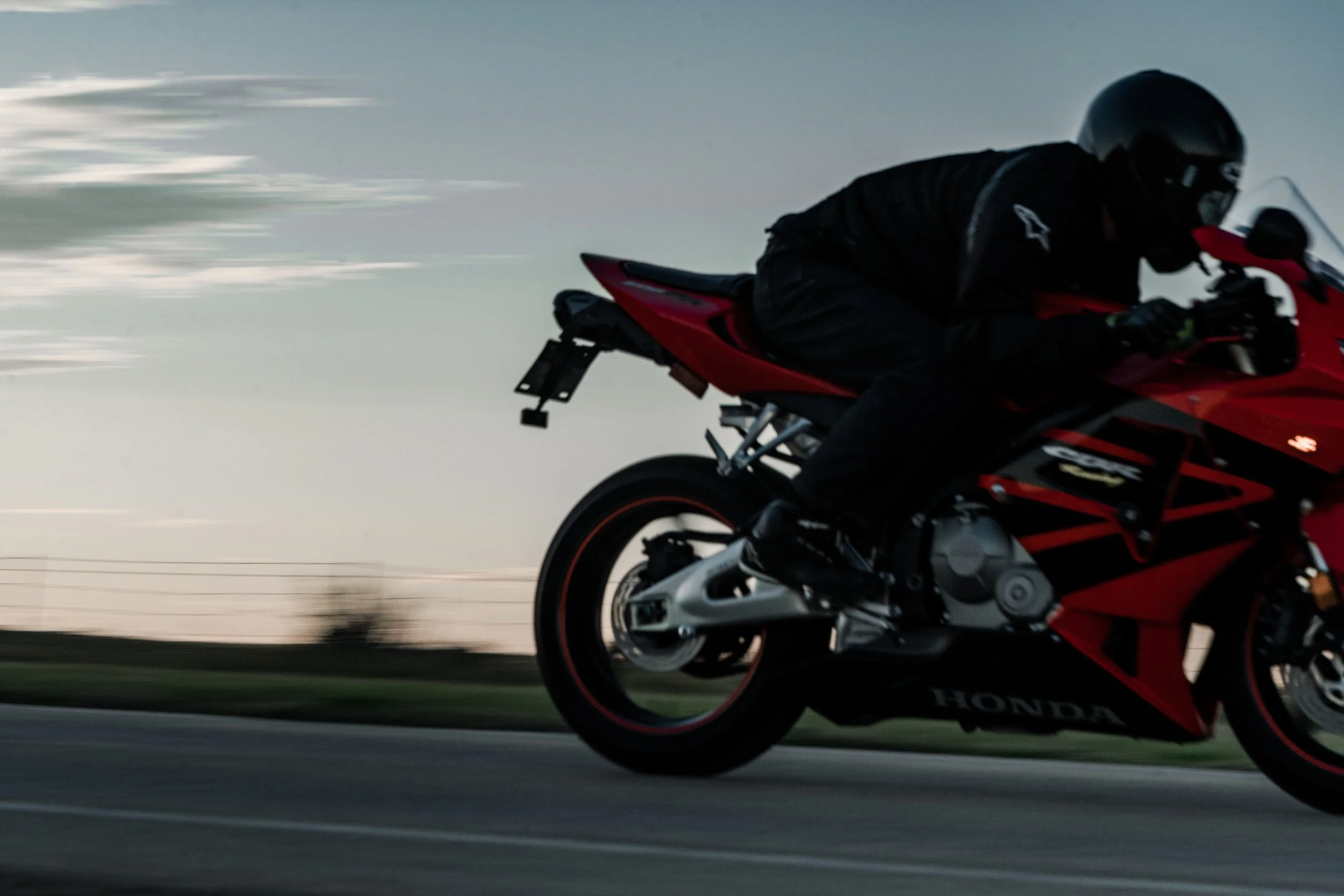 Motorcyclist on red Honda CBR rides past camera at high speed on highway outside of Edmonton | Edmonton motorcycle photographer DarkShark Media