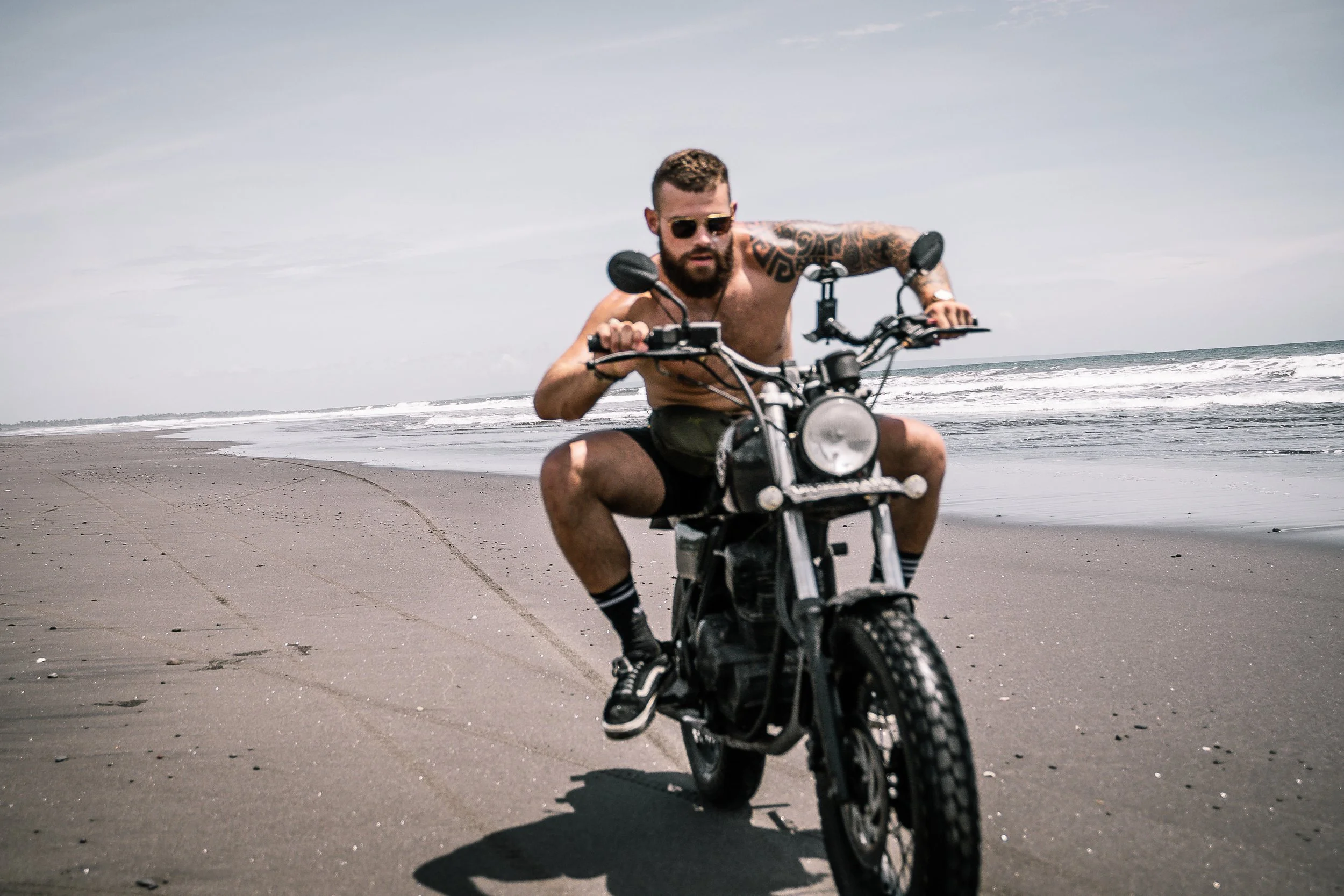 Man in sunglasses rides motorcycle past camera on the beach | Edmonton motorcycle photographer DarkShark Media