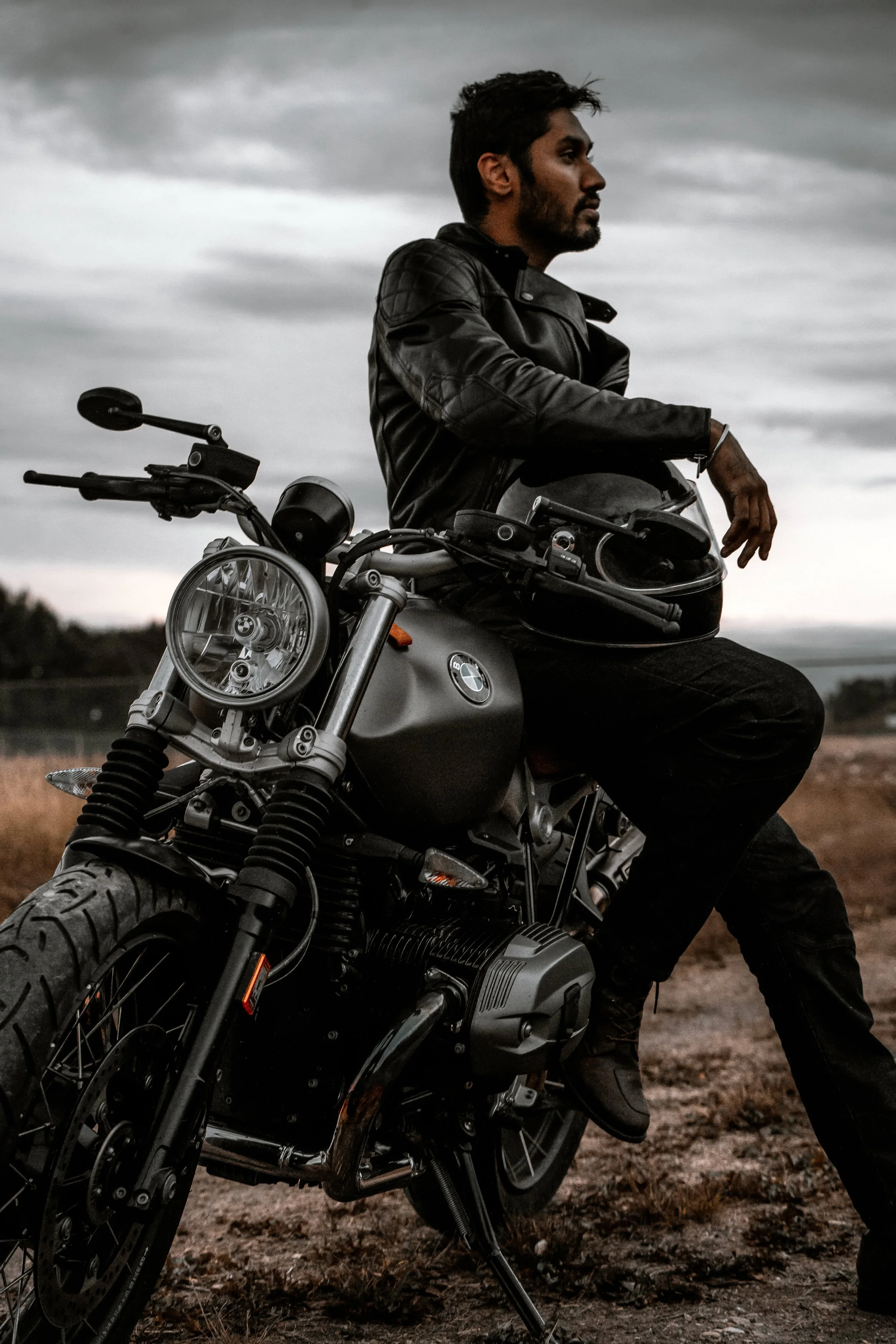 Male model posing on motorbike with helmet on lap | Edmonton motorcycle photographer DarkShark Media