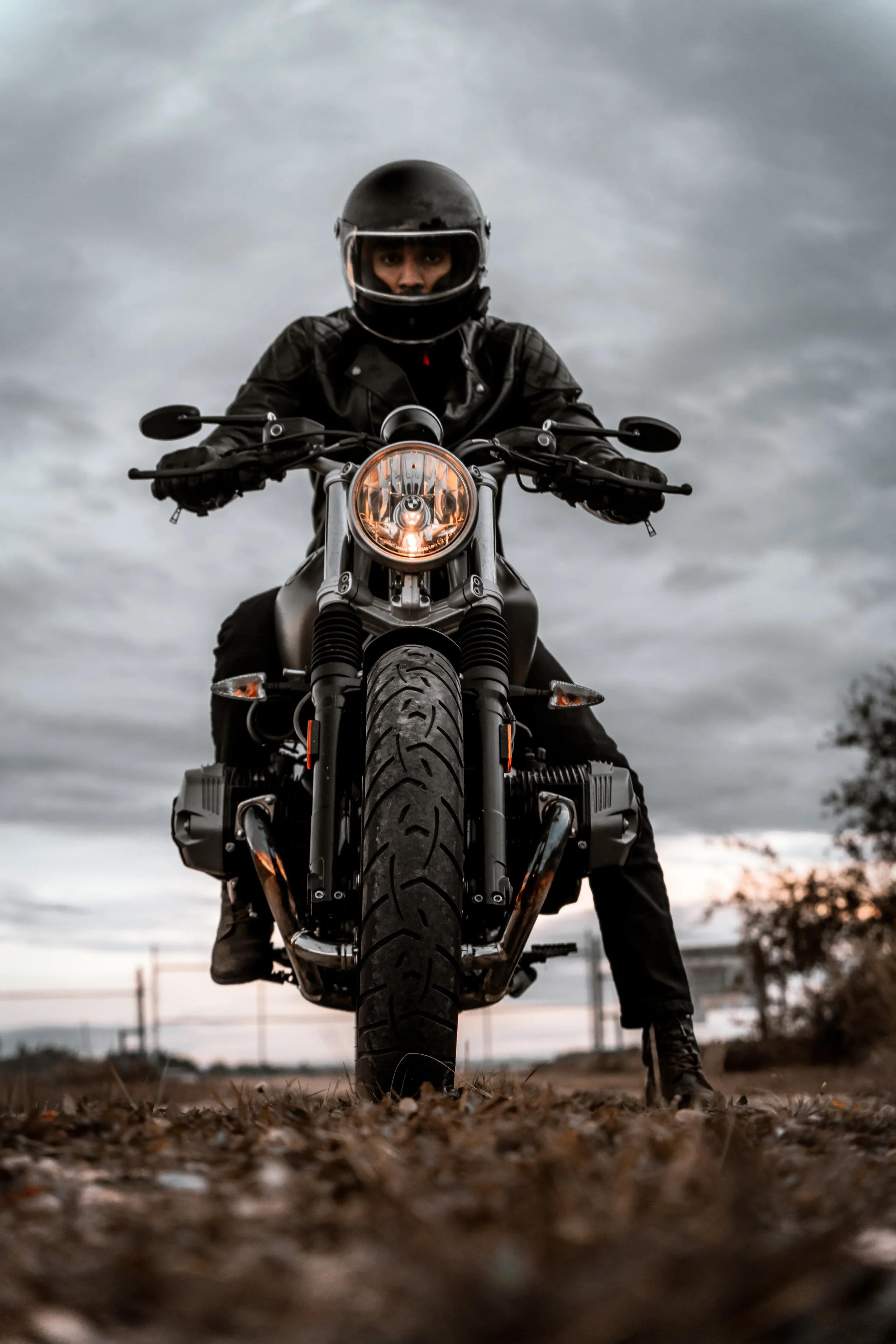Man sits on BMW R Nine T Motorcycle while looking at camera | Edmonton motorcycle photographer DarkShark Media