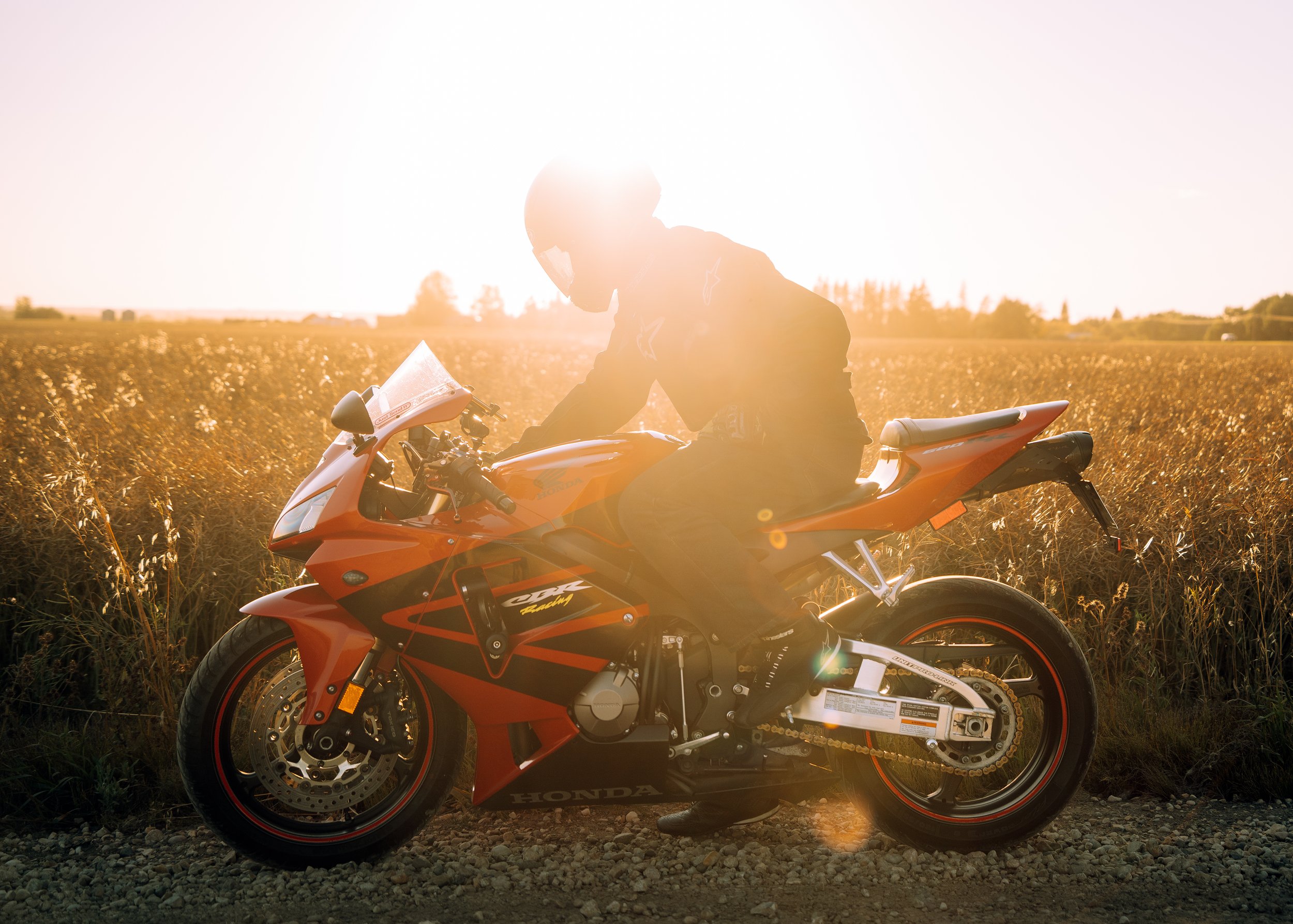 Rider sitting on his motorcycle in front of field at sunset | Edmonton motorcycle photographer DarkShark Media