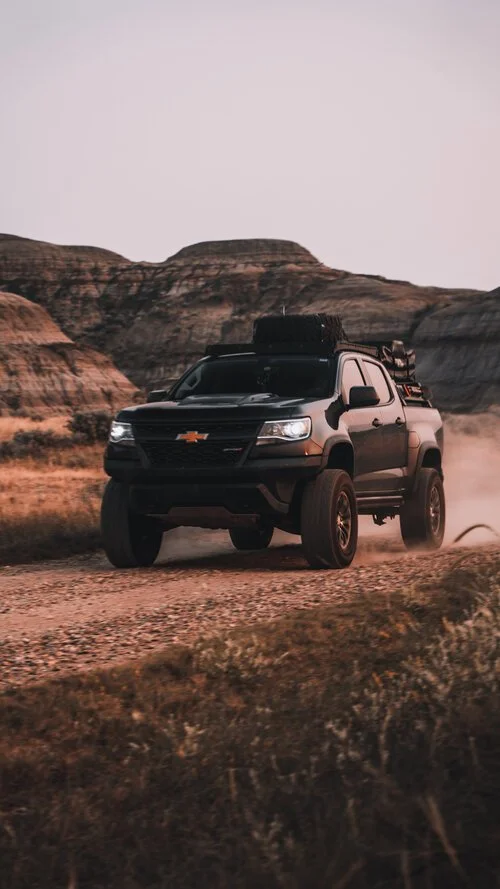Chevrolet Colorado ZR2 driving past hoodoos in Drumheller, Alberta | Edmonton automotive photographer DarkShark Media
