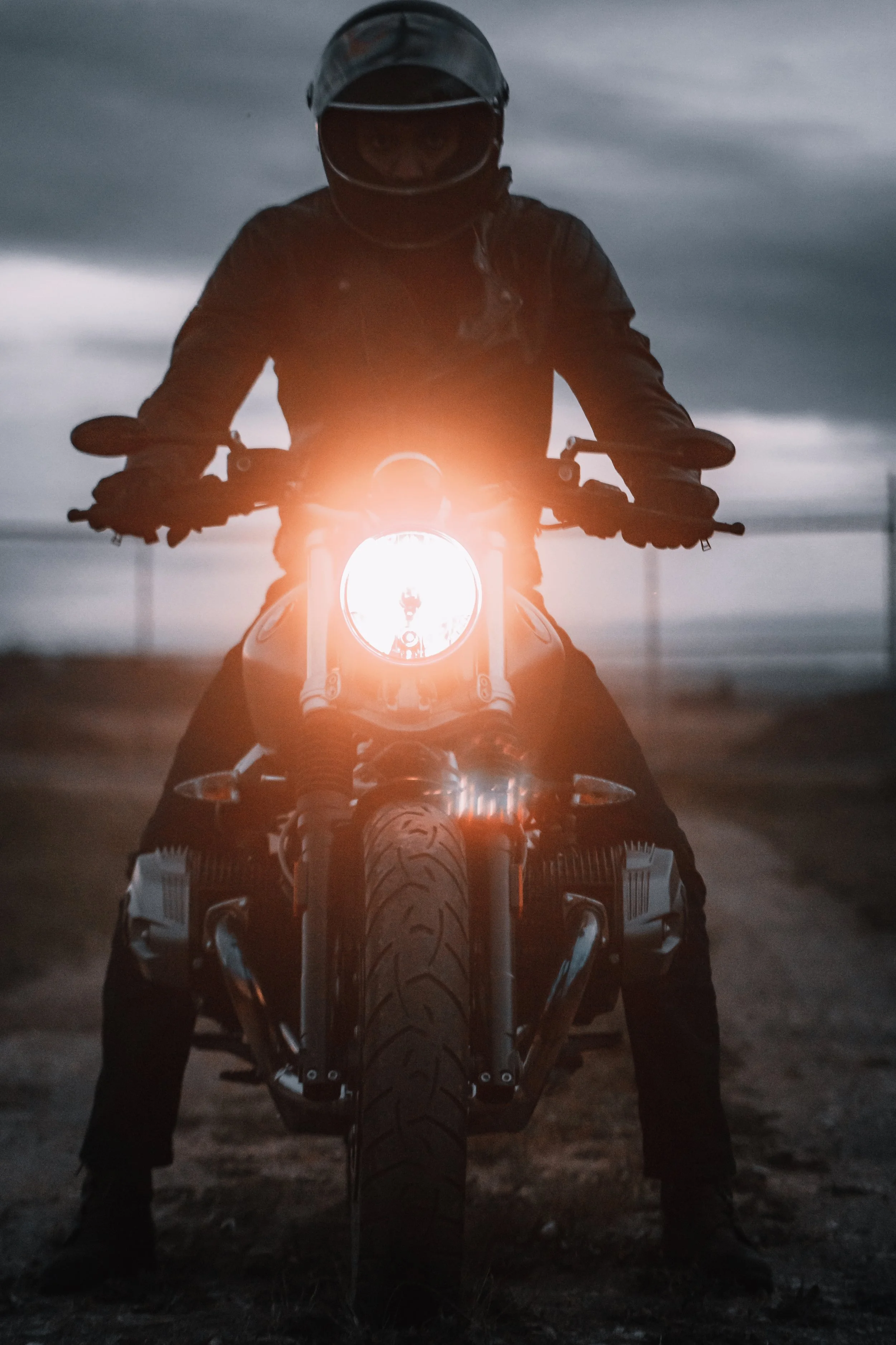 A motorcycle rider sits on his BMW R Nine T facing the camera with headlight on | Edmonton motorcycle photographer DarkShark Media