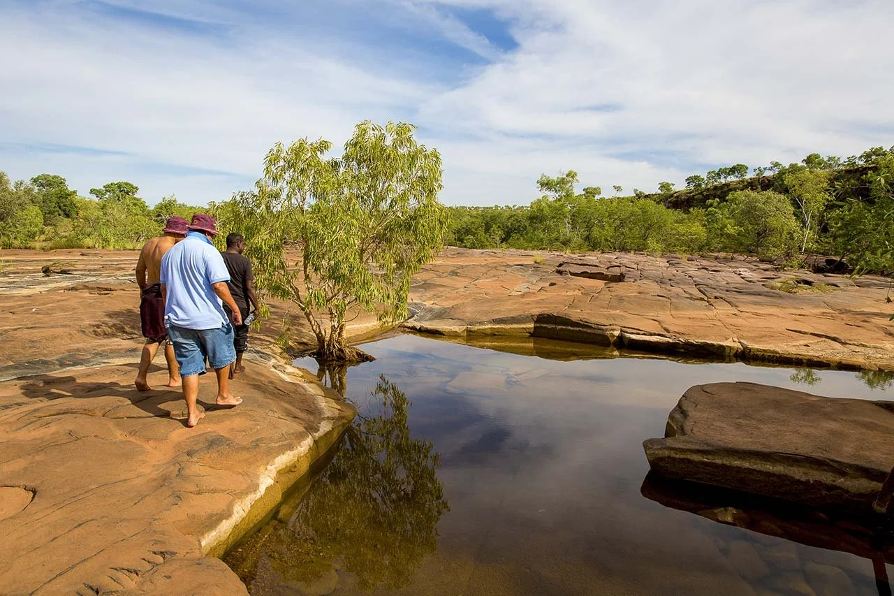 three-men-standing-near-waterhole.jpg