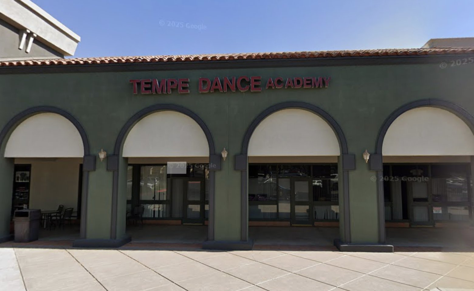 Fron of a building with a sign that reads 'Tempe Dance Academy' against a light green wall with four arched windows.