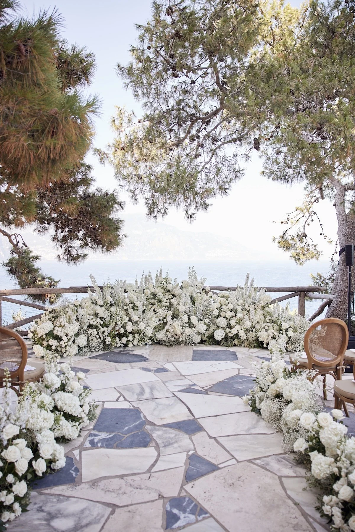 Floral-lined ceremony aisle overlooking the sea for a private island destination wedding, captured by Lost In Love Photography.