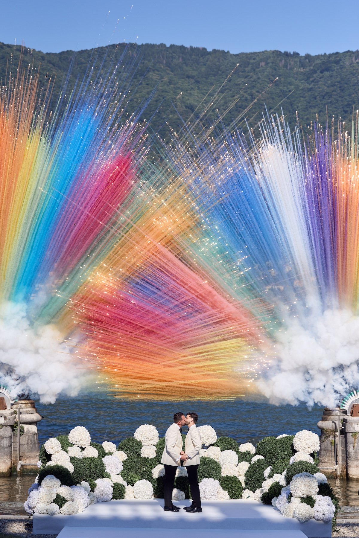 Destination wedding photographers, Lost in Love Photography capturing a lakeside wedding ceremony with colorful fireworks and floral décor.