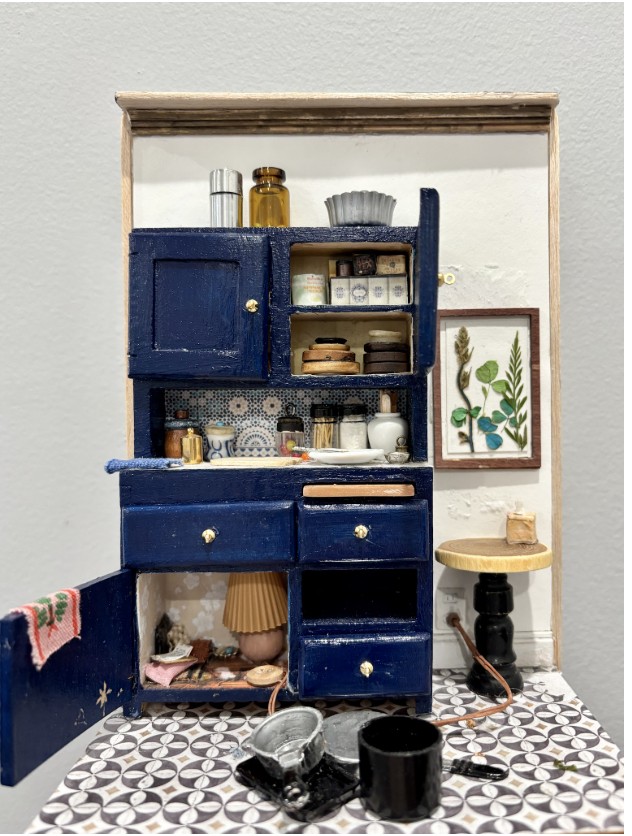 Clara Campos
Hideout, 2025
Dollhouse kitchen cabinet, paint, balsa wood, buttons, beads, silverware, wood pieces, fabric, chess piece table, jewelry metal
7 x 5 x 3 in