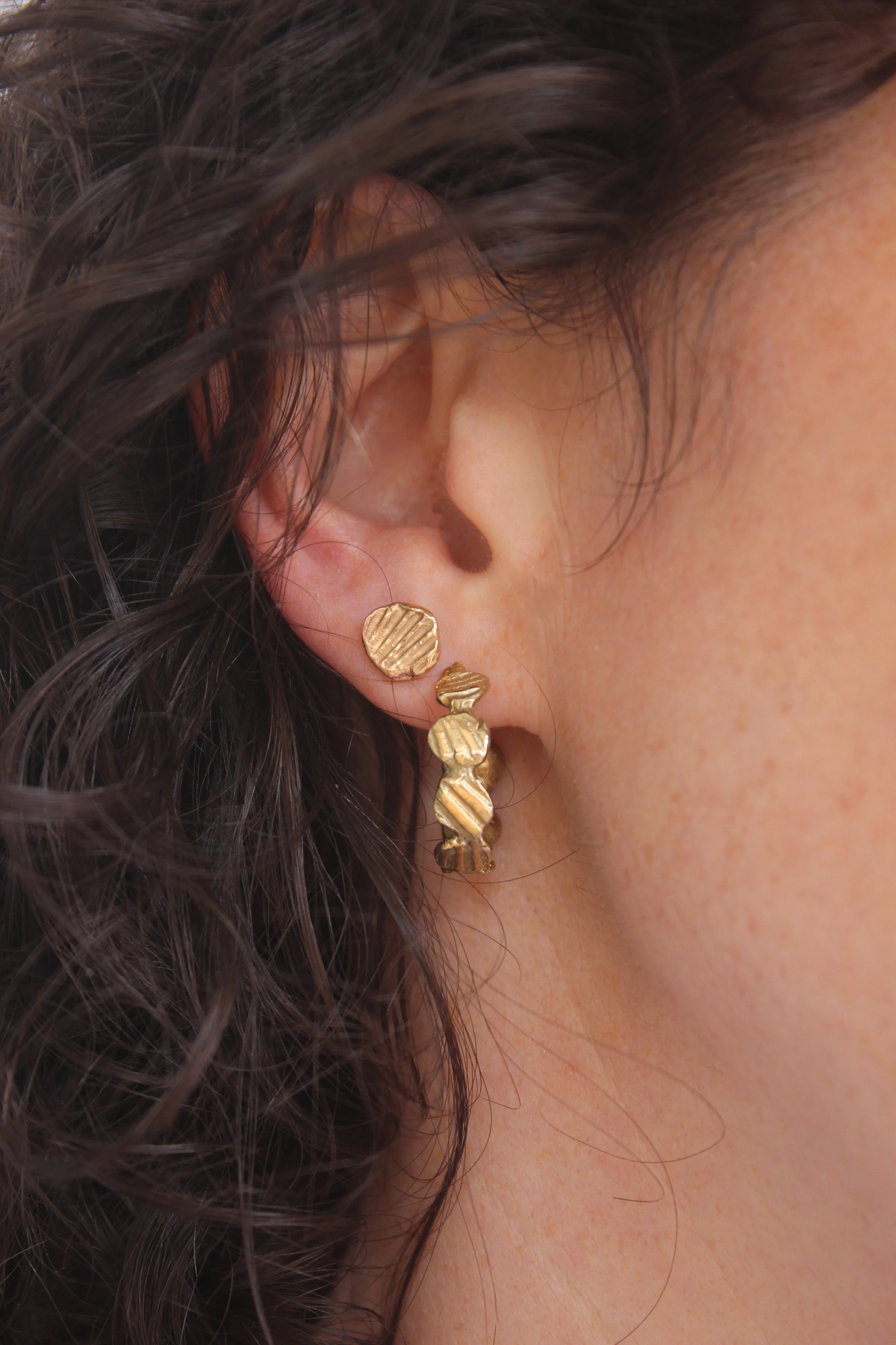 model wearing gold earring hoop and stud moulded from seashells