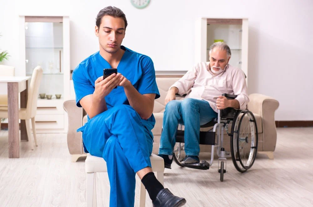 A nurse neglecting a man in a wheelchair