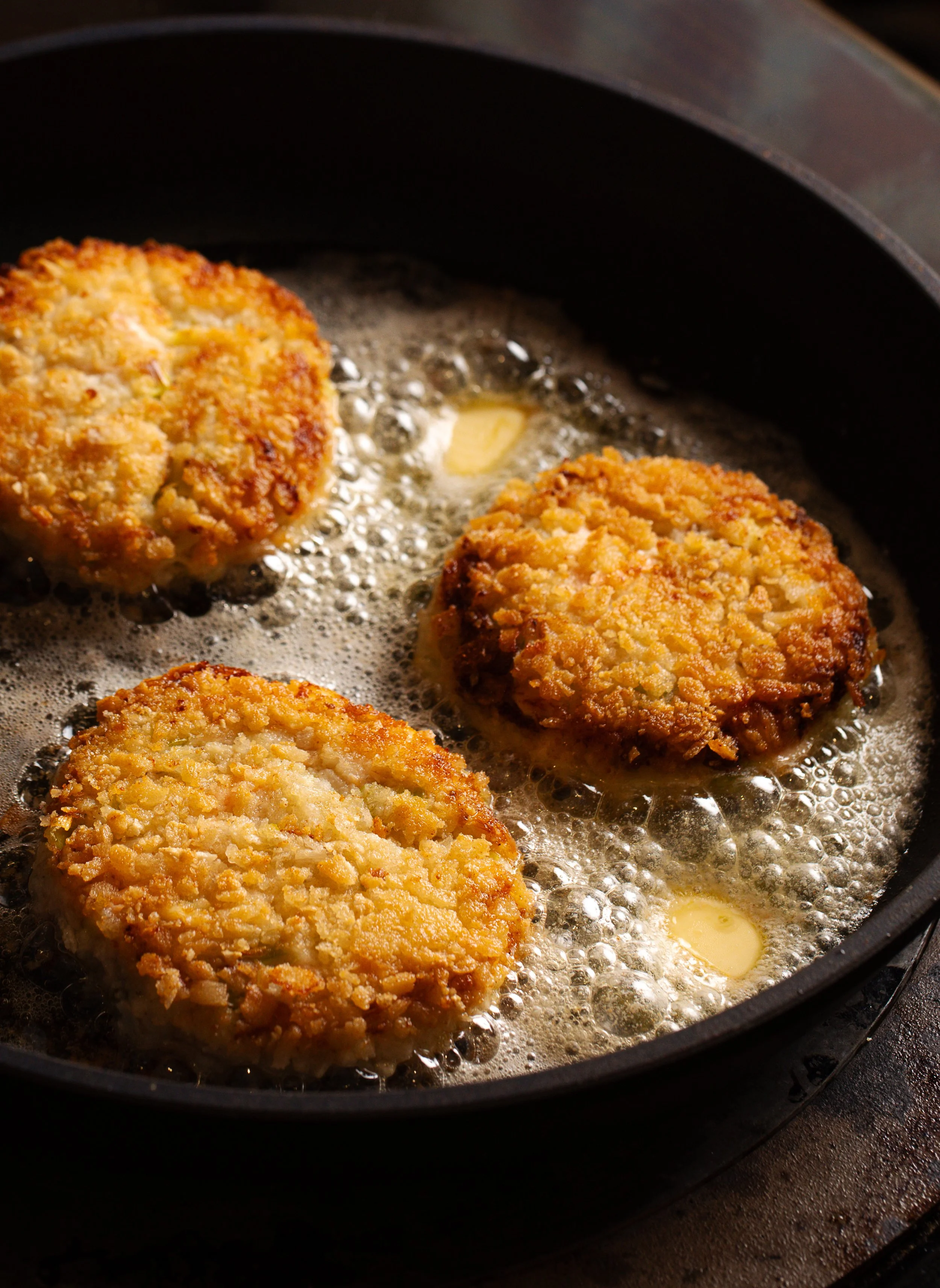 fishcakes sizzling in pan