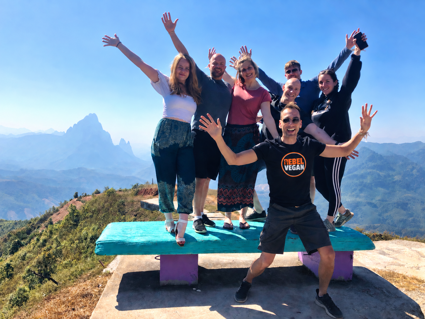 Photo of Todd Sinclair with tour group standing at a look out point smiling in celebration
