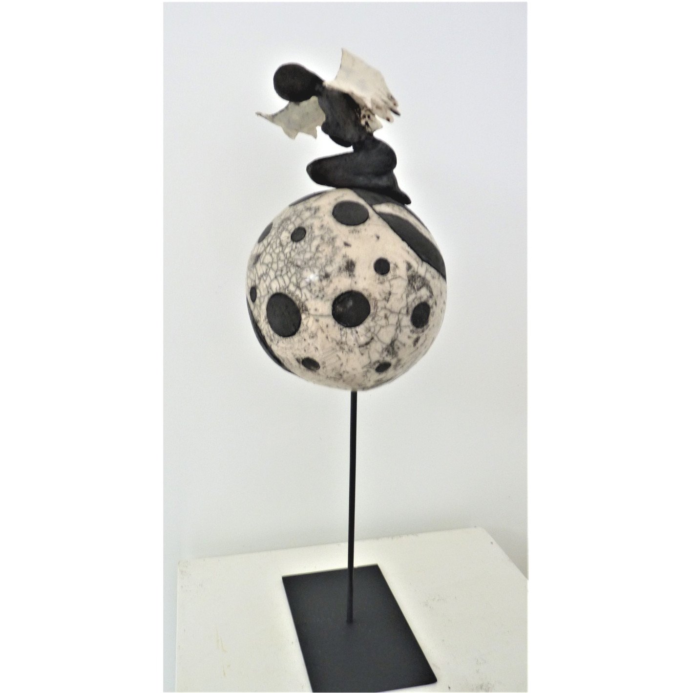 Sculpture 'Dualité I' en Raku, représentant une figure féminine avec des ailes blanches contrastant avec une base sombre.