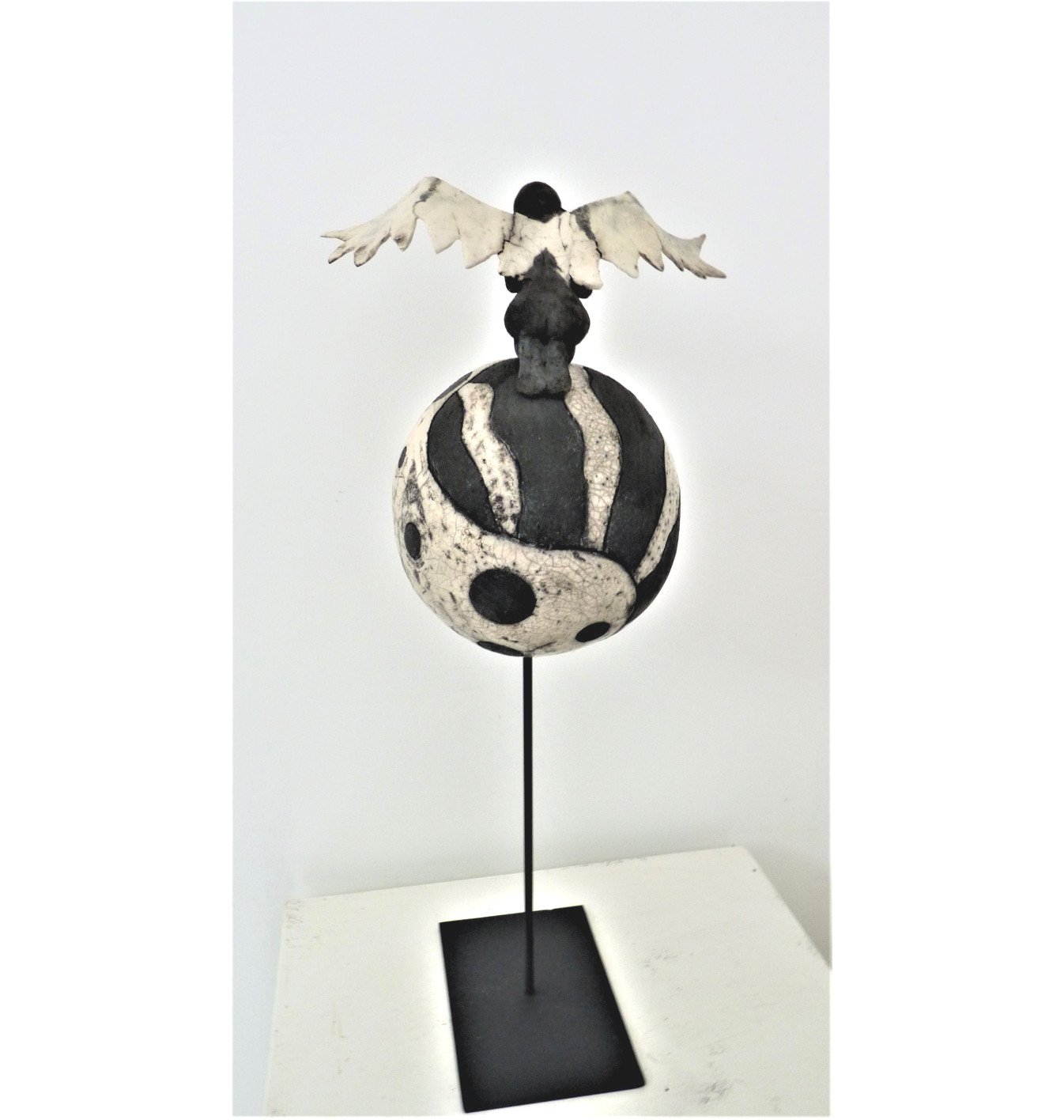 Sculpture 'Dualité I' en Raku, représentant une figure féminine avec des ailes blanches contrastant avec une base sombre, vue d'ensemble.