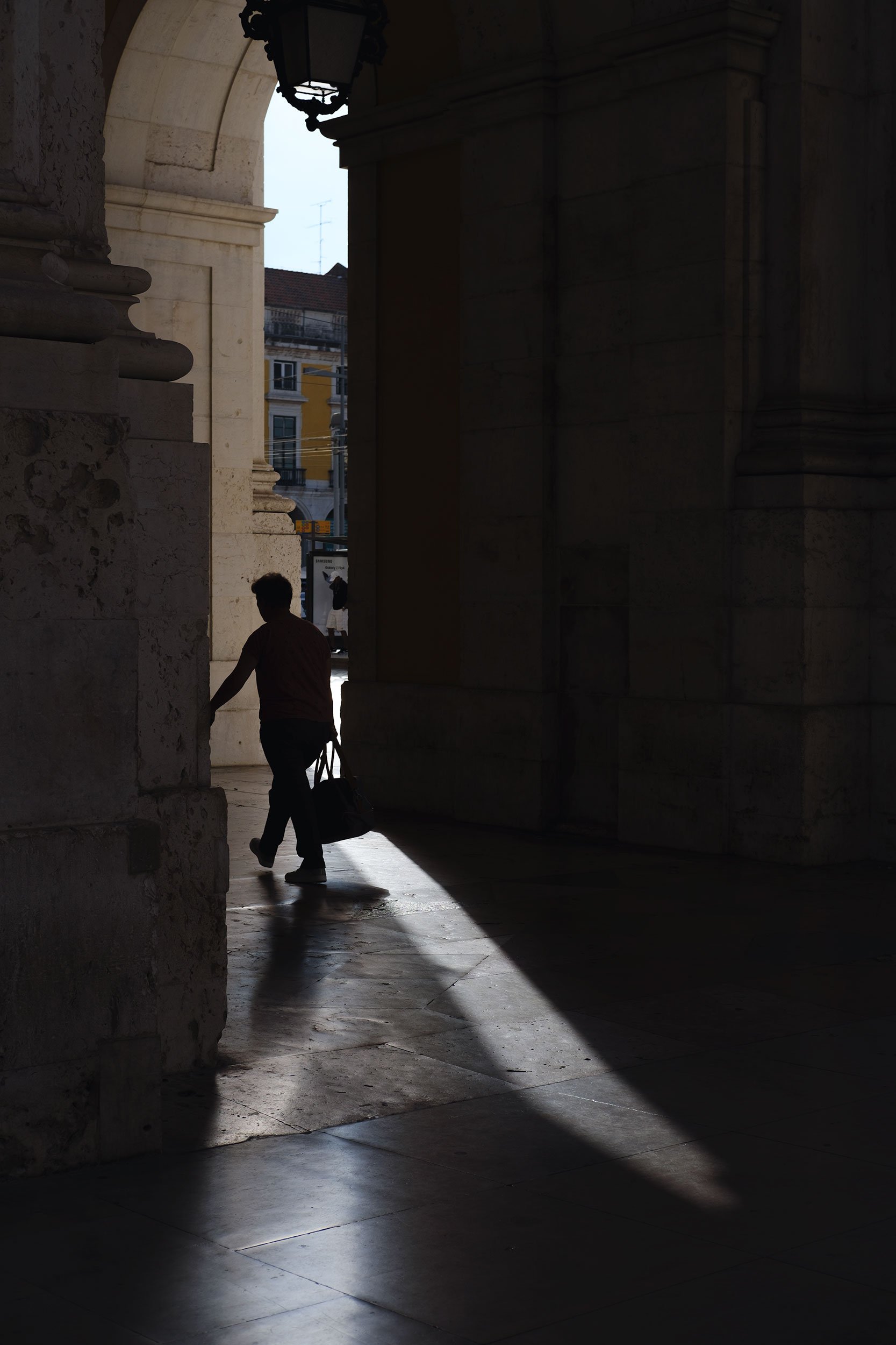 Man carrying a bag walking in Lisbon.