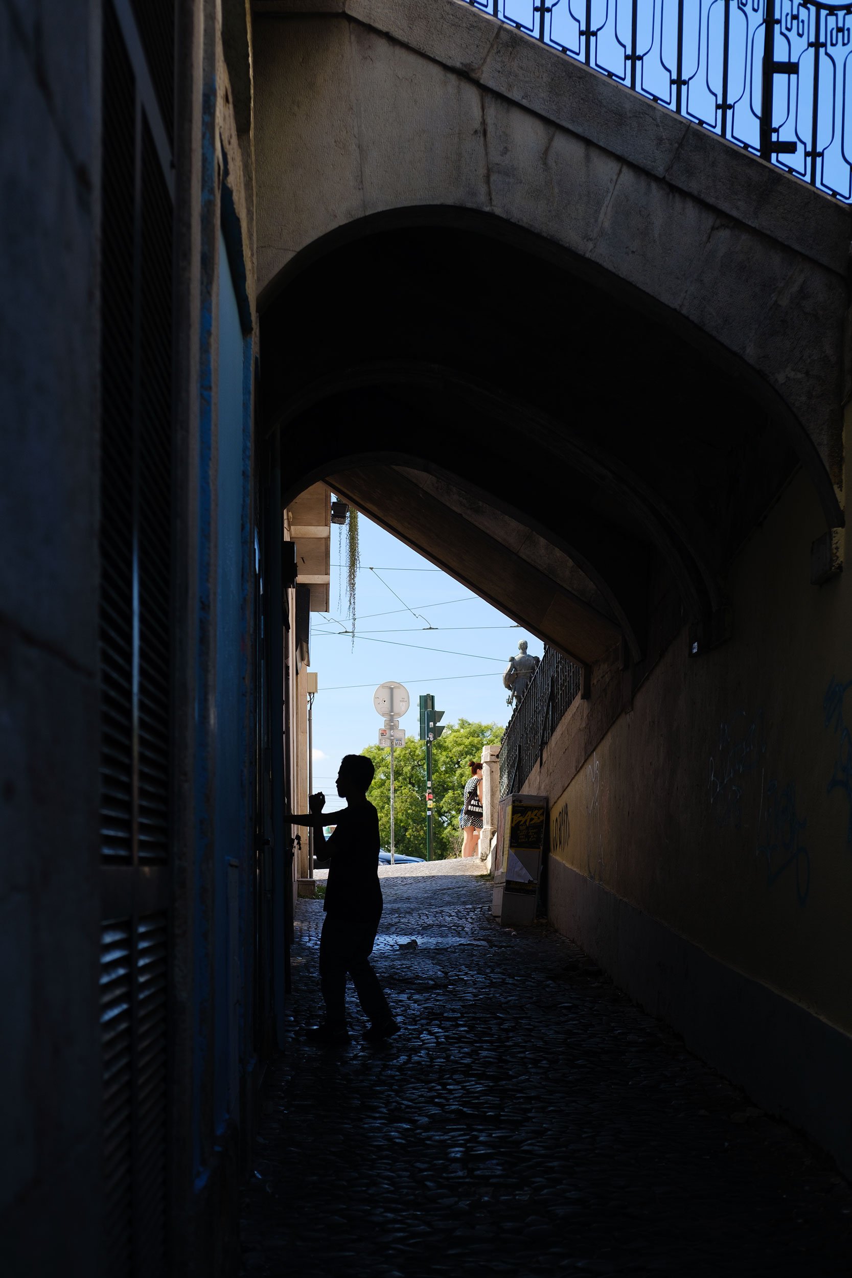 Man in silhouette in Lisbon alley.