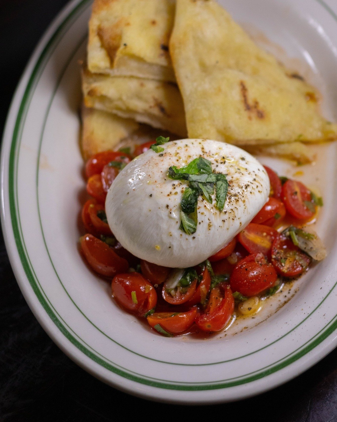 Our new burrata appetizer is a beauty inside &amp; out. Served with marinated tomatoes, basil &amp; grilled bread, cut it open to reveal a creamy, rich center 🍅🥖🧀