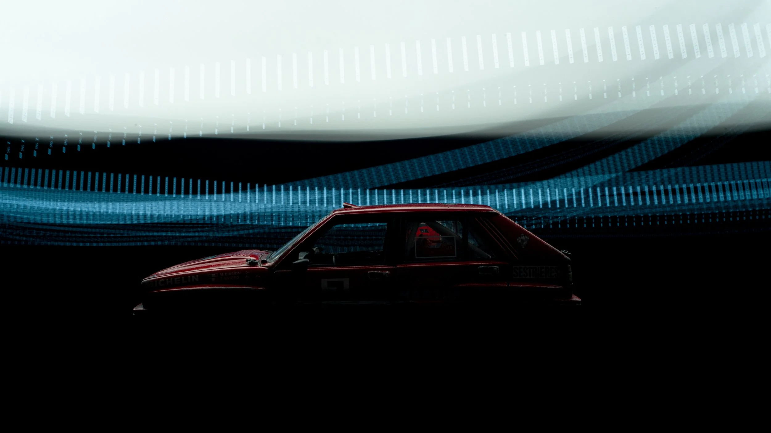 Ein Rennwagen vor einem digitalen, futuristischen Hintergrund mit blauen, weißen und schwarzen Lichtstreifen.