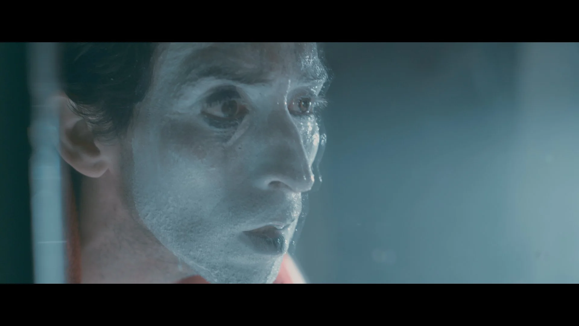 Nahaufnahme eines Mannes mit einem Gesichtsschwamm in einem Spa oder Badezimmer, der Gesichtspflege durchführt.