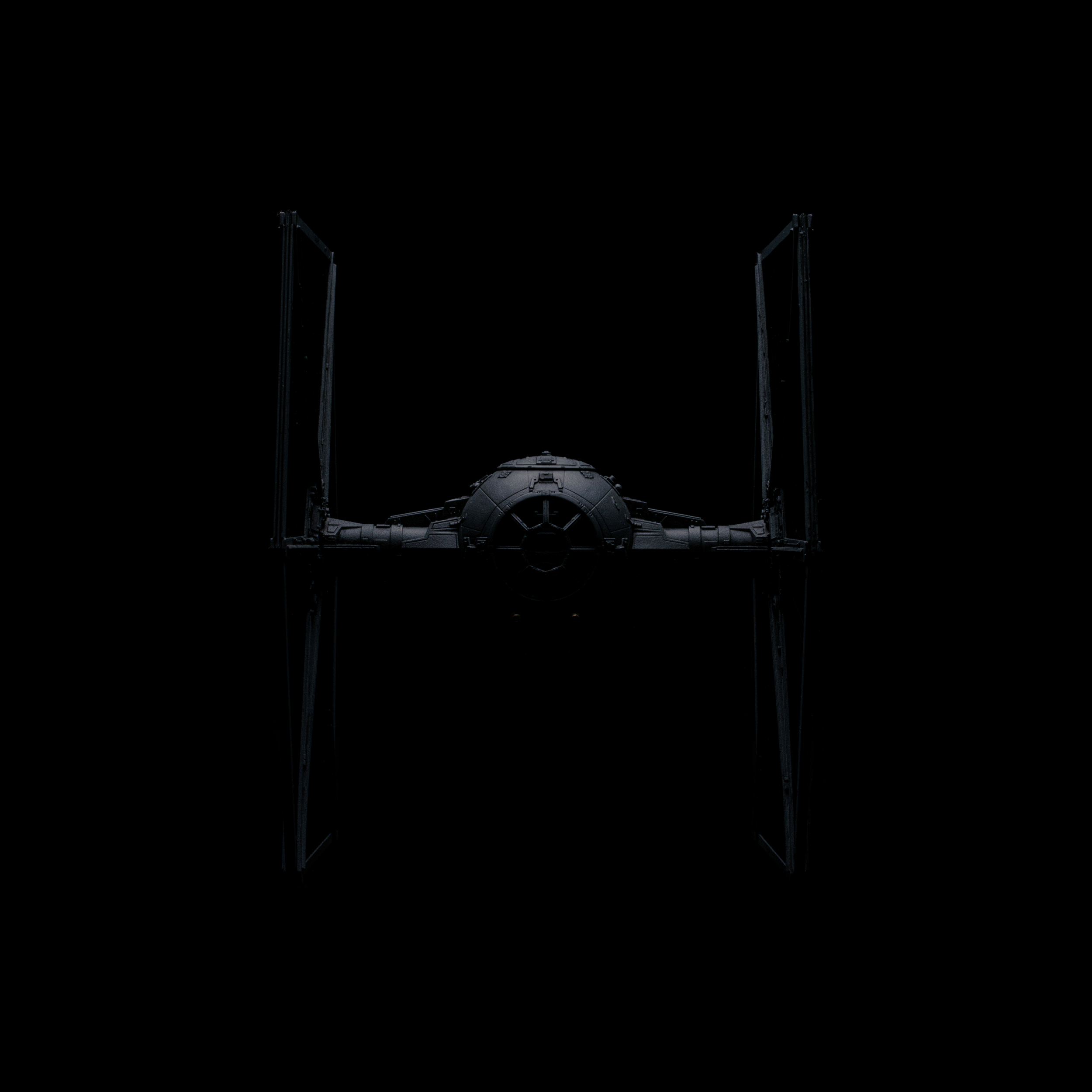Das Bild zeigt ein Raumschiff, das wie ein TIE Fighter aus dem Star Wars Universum im dunklen Weltraum schwebt.