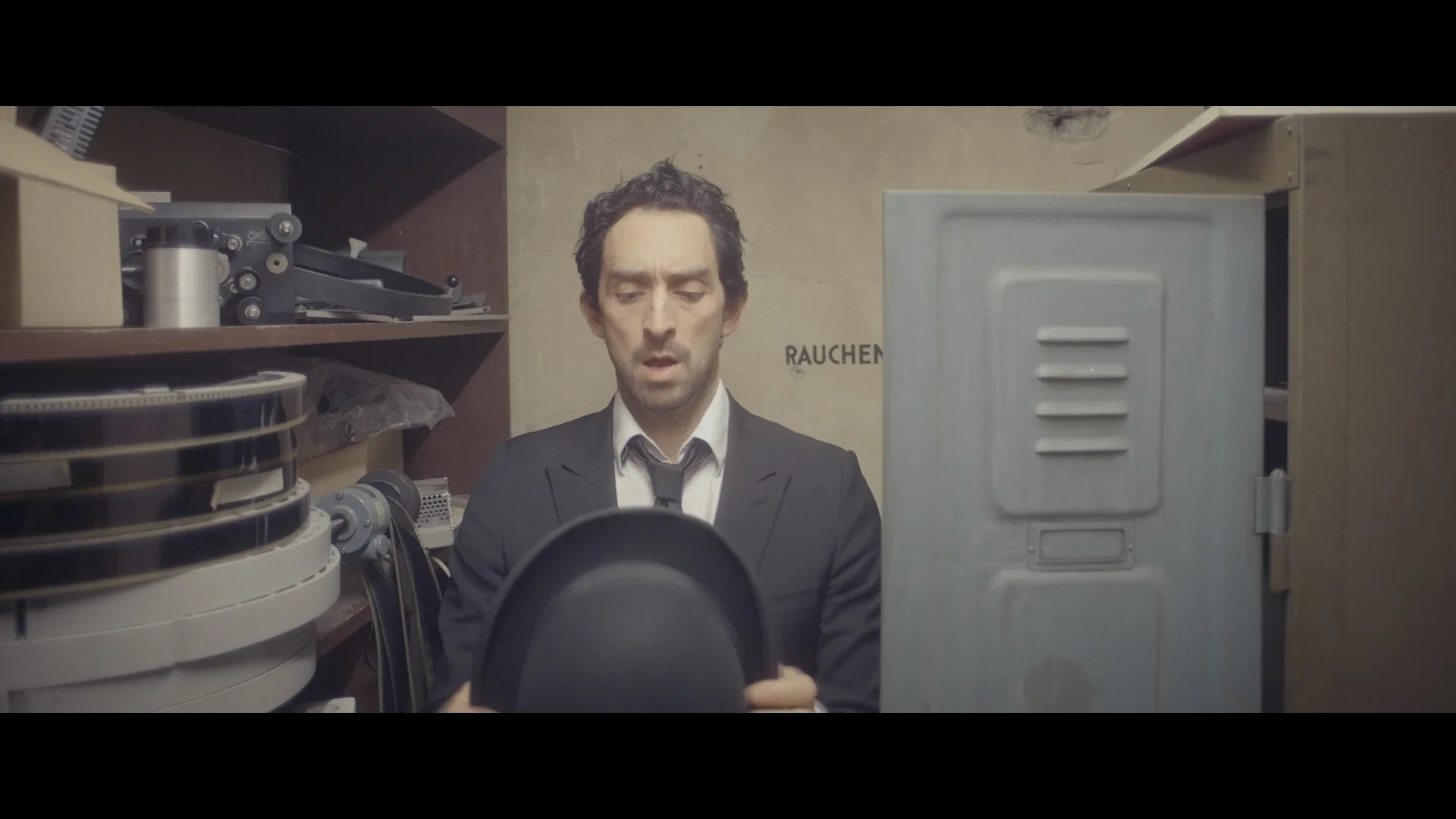 Man in Anzug öffnet einen Aktenkoffer in einem Lagerraum.