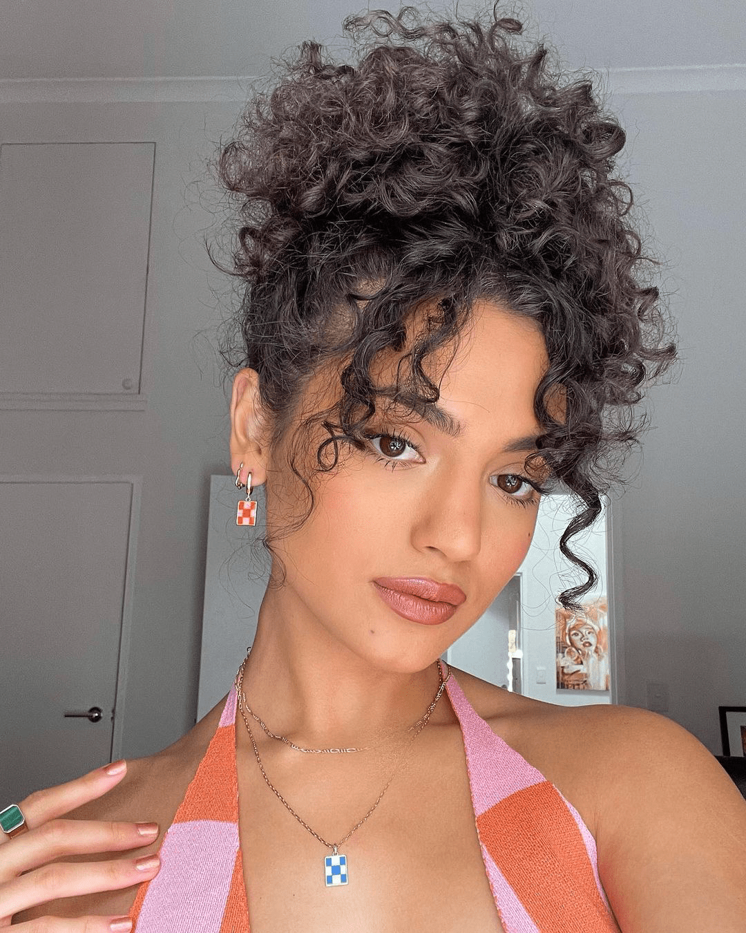 Effortless Pinned Tendrils for Short Natural Curls with voluminous updo and soft face-framing tendrils.