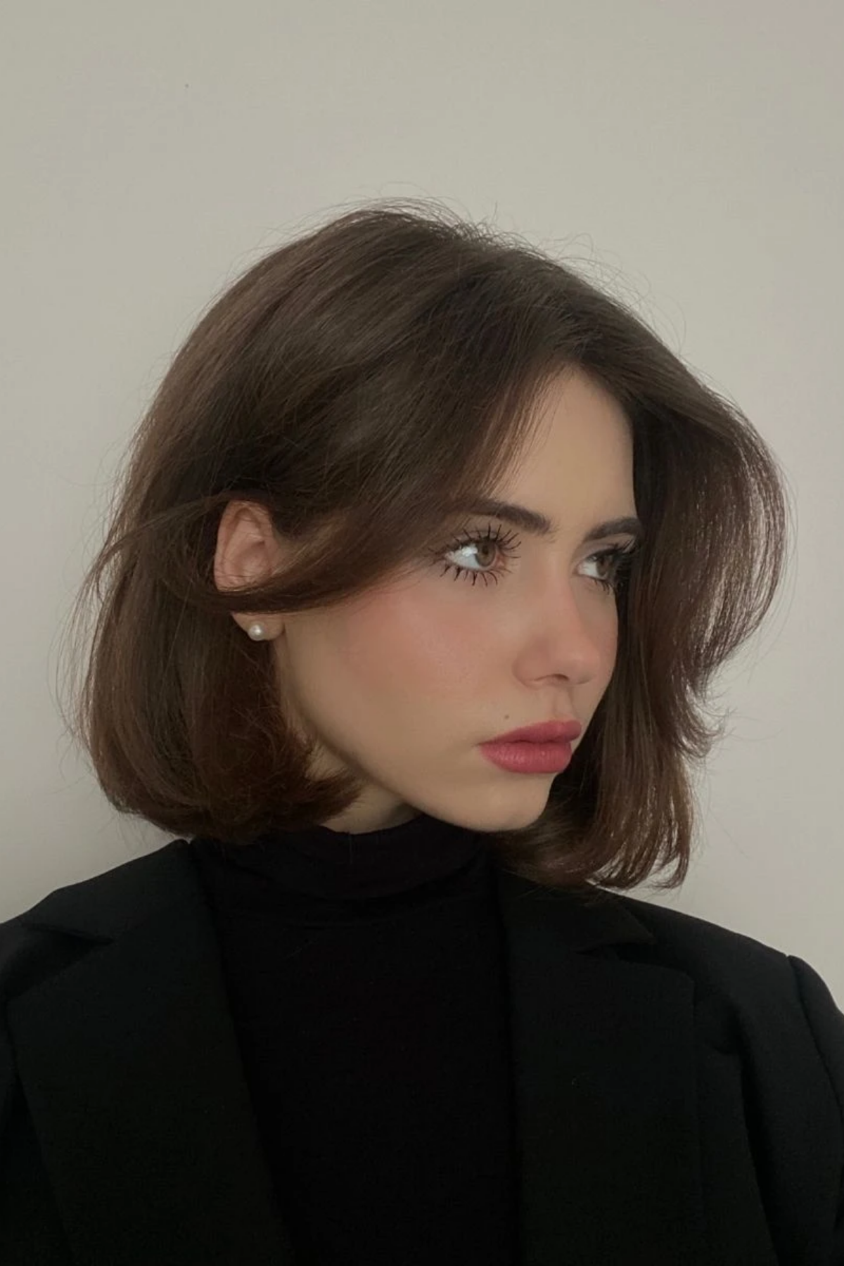 Chin-length bob worn with a black turtleneck, the high neckline showing the shape of the cut