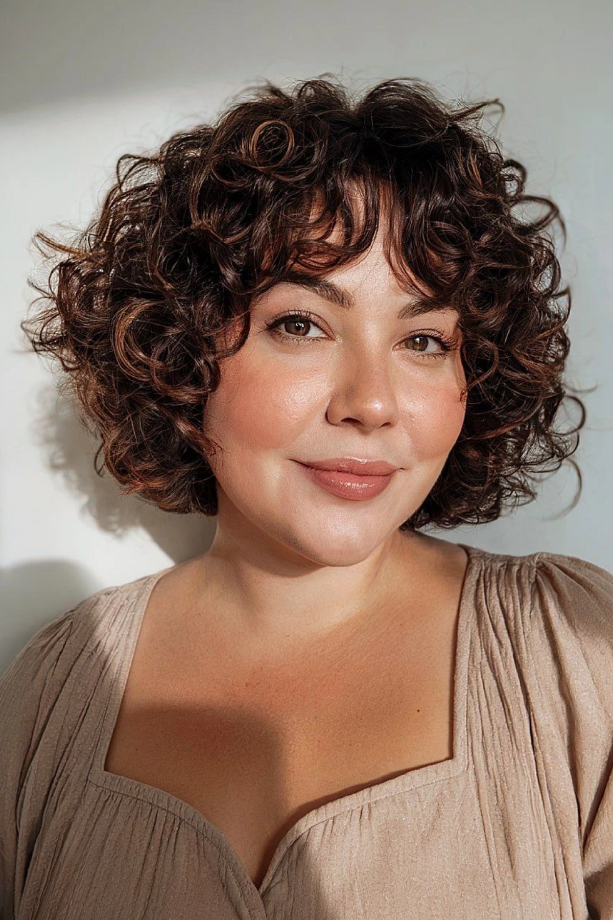 Curly bob whose length accounts for shrinkage, curls sitting at the chin