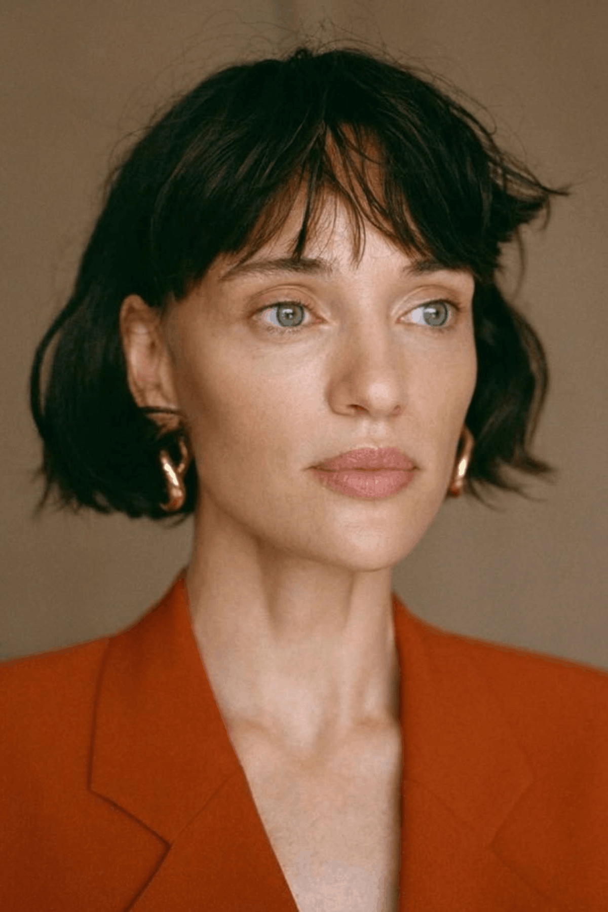 Front-facing image of a person wearing The Soft Feathered Bob, featuring a bob haircut with feathered ends, light volume, and airy layering that softens the overall shape.