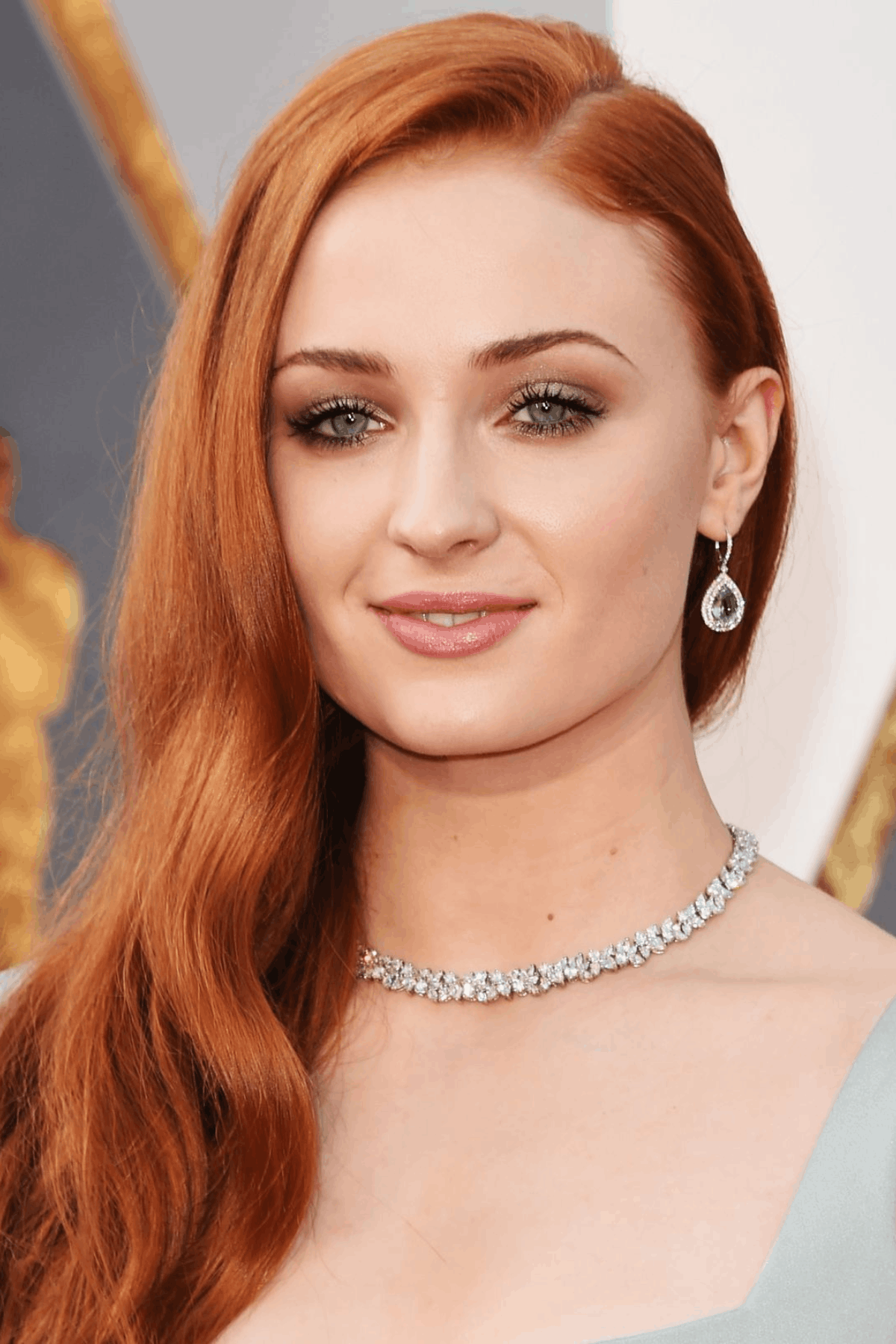 Portrait of a woman with apricot orange hair, styled in smooth waves with a soft, subtle warm tint.