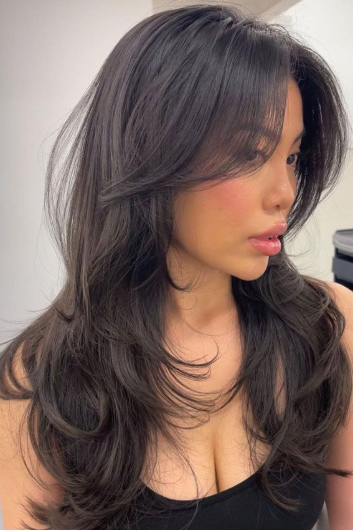 Girl wearing Long Hair with Curtain Bangs haircut, framing the face lightly while avoiding heavy fringe in summer heat.