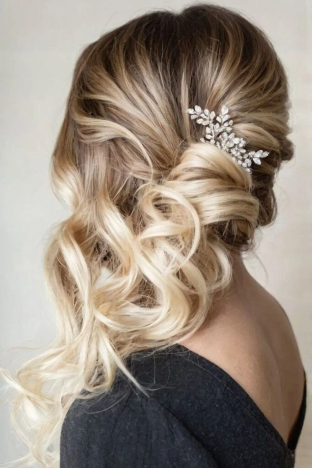 Asymmetrical bridal half-updo with flattering face-framing waves.