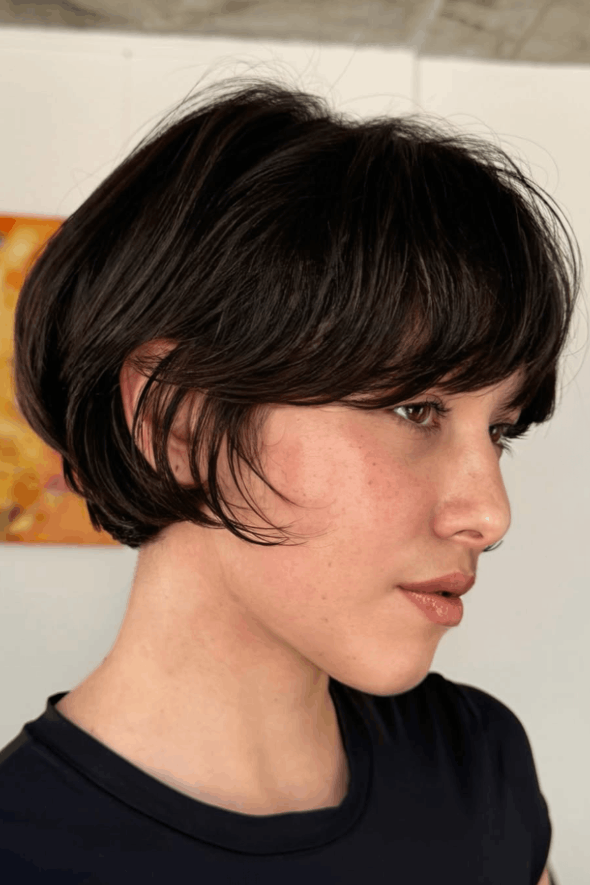 Woman with a short bixie butterfly hybrid, combining a cropped bob length with soft, airy butterfly layers and light fringe for a blended pixie-bob effect.