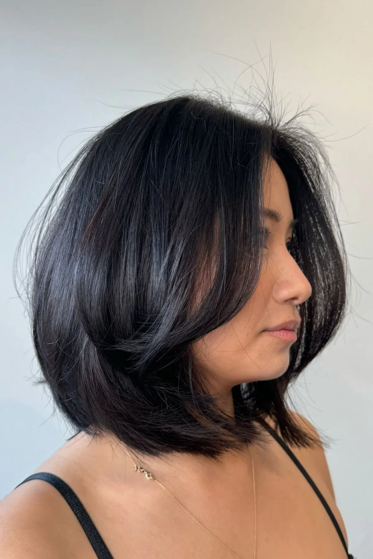 Woman with a Layered Lob with Face-Framing Pieces haircut, combining soft layers and front sections that contour the face.