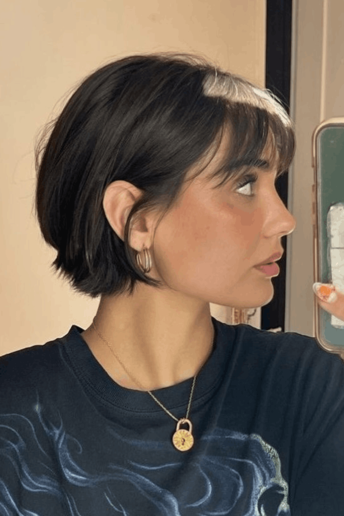 Side-profile image of a person wearing The Hybrid Lob-Pixie (“Plob”) with Movement, blending short pixie length at the nape with longer bob sections, creating visible motion and texture through the sides.
