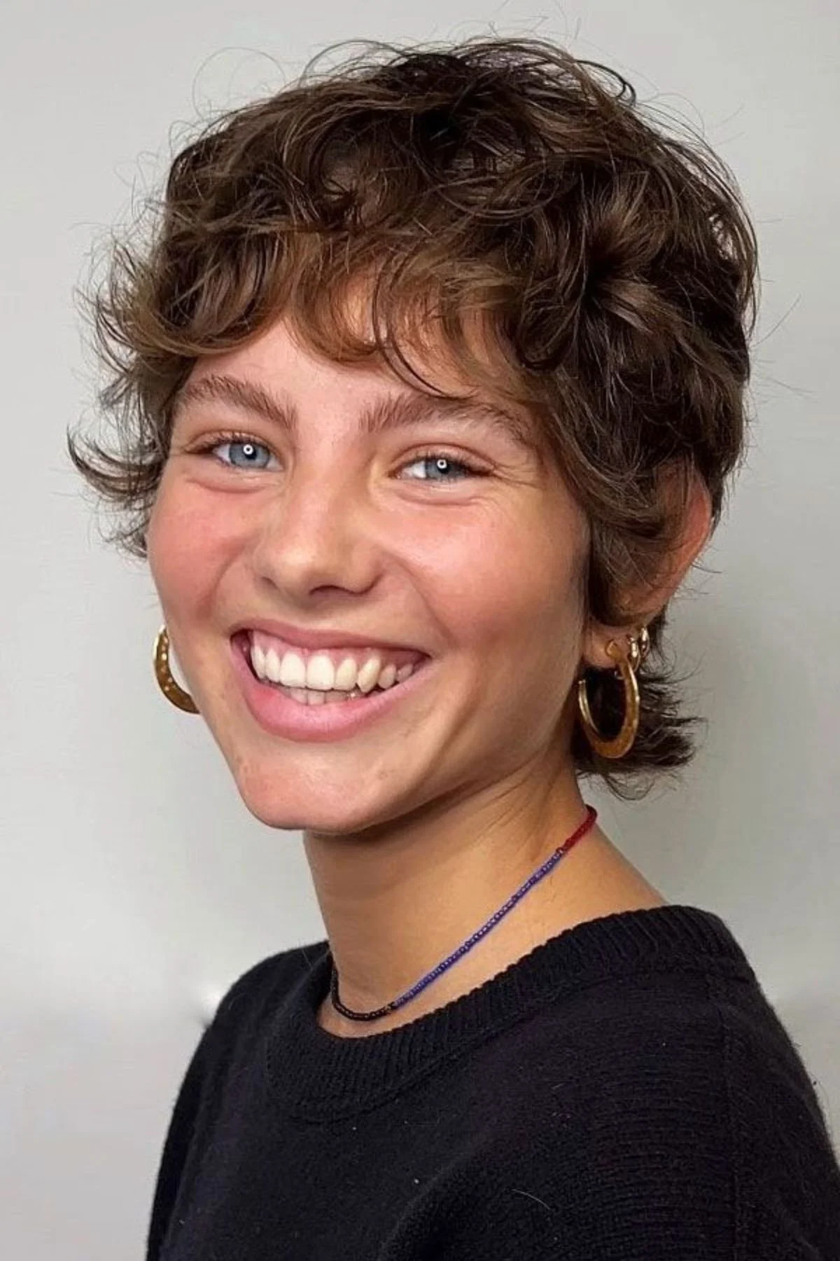 Girl with a Curly Wash-and-Go Cut haircut highlighting natural curls shaped for easy low-maintenance styling.