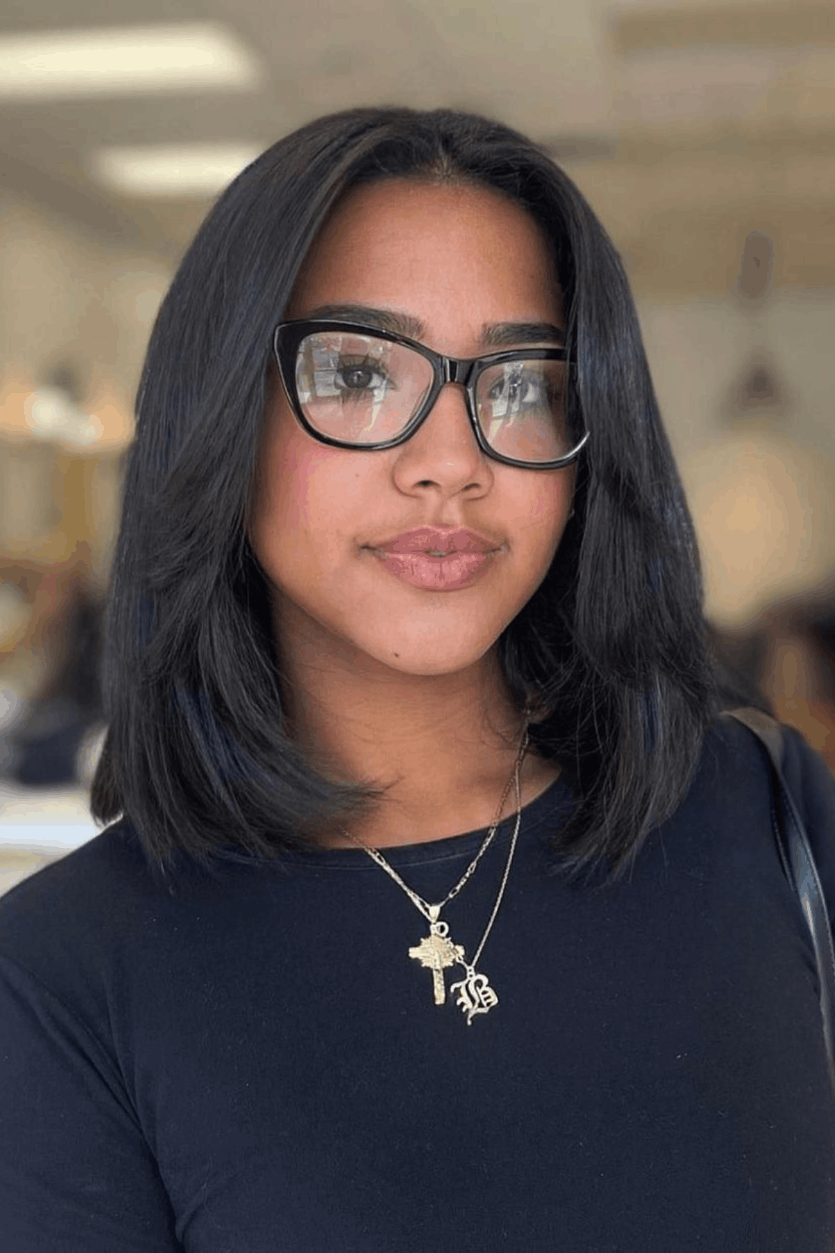 Woman with a short butterfly bob, cut around jaw length with soft, feathered layers adding light volume and subtle outward flicks.