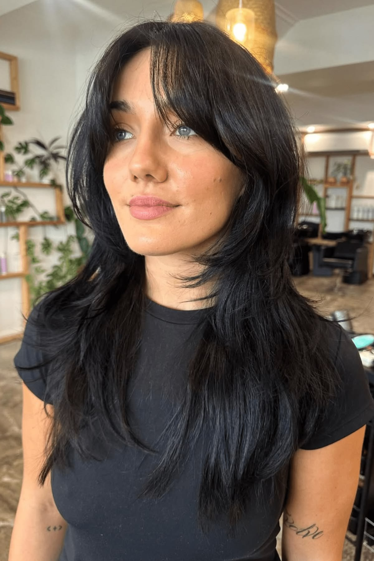 Woman styled in a Soft Wolf Cut haircut, combining volume and layers for a trendy yet lightweight summer feel.