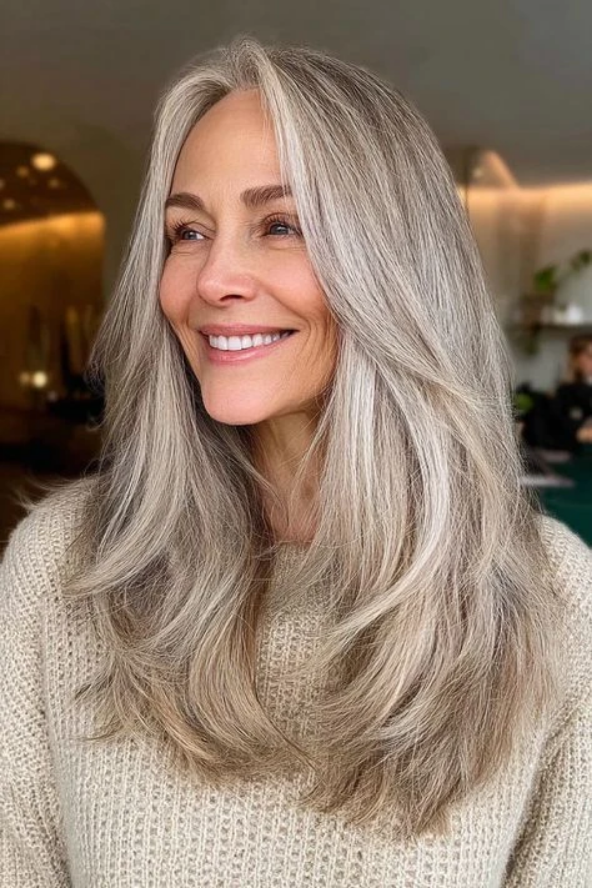 Long layered haircut on a woman in her fifties with long natural silver hair