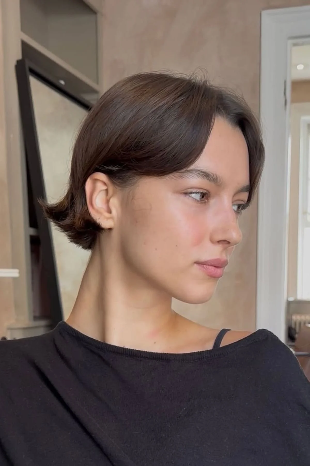 Woman showcasing a Mini Blunt Bob for Fine Hair, featuring a short crisp cut designed to enhance fullness and density.